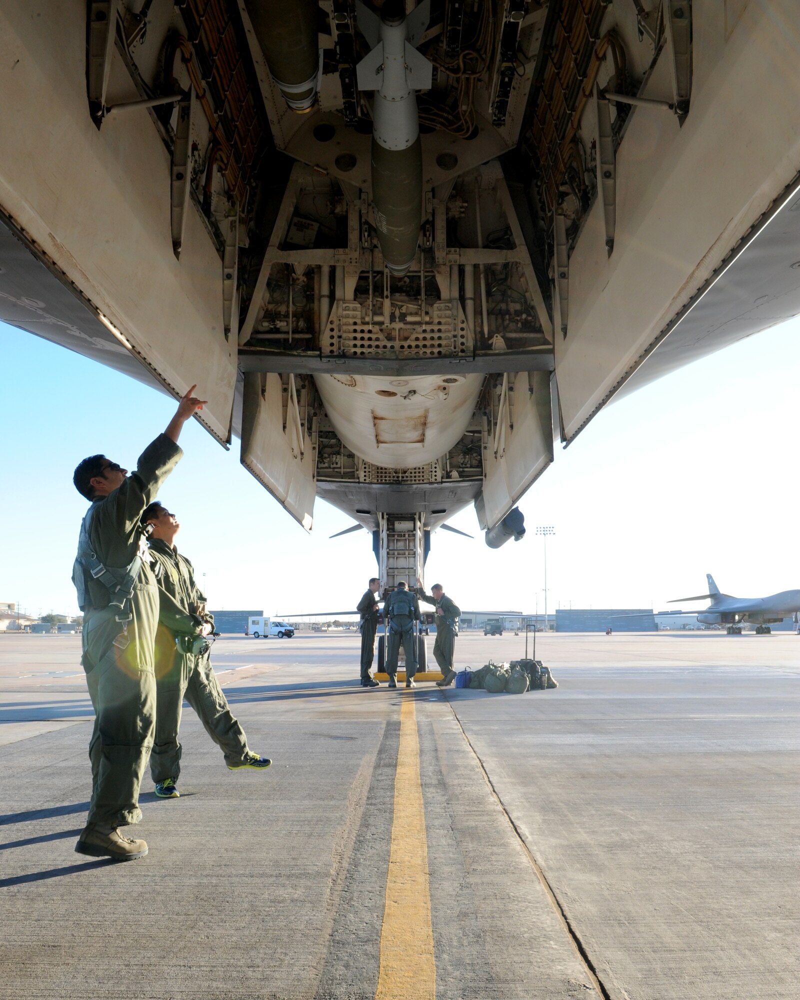 U.S. Air Force Maj. Larry Requenez, 28th Bomb Squadron, talks to Lyndon Soe, visitor, about the capabilities of a B-1 Bomber and the testing of a BLU-129 warhead, Jan. 20, 2012, at Dyess Air Force Base, Texas. The BLU-129 is a 500-pound guided bomb designed with a composite warhead to destroy targets while causing the least amount of collateral damage. (U.S. Air Force photo by Airman 1st Class Jonathan Stefanko/Released)