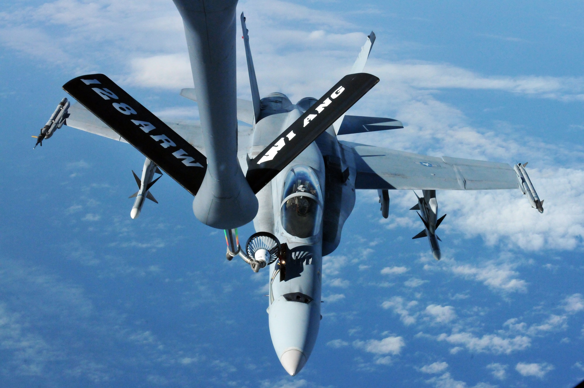 Crews from the Wisconsin Air National Guard's 128th Air Refueling Wing conduct an in-flight refuel with a Marine F-18 Hornet from the Marine Fighter Attack 314 out of Miramar, Calif., Jan. 12, 2012. The Marines served as adversaries to pilots of the Madison-based 115th Fighter Wing during simulated combat over the course of a two-week joint training exercise at Naval Air Station Key West, Fla. (Air National Guard photo by Tech. Sgt. Jon LaDue)