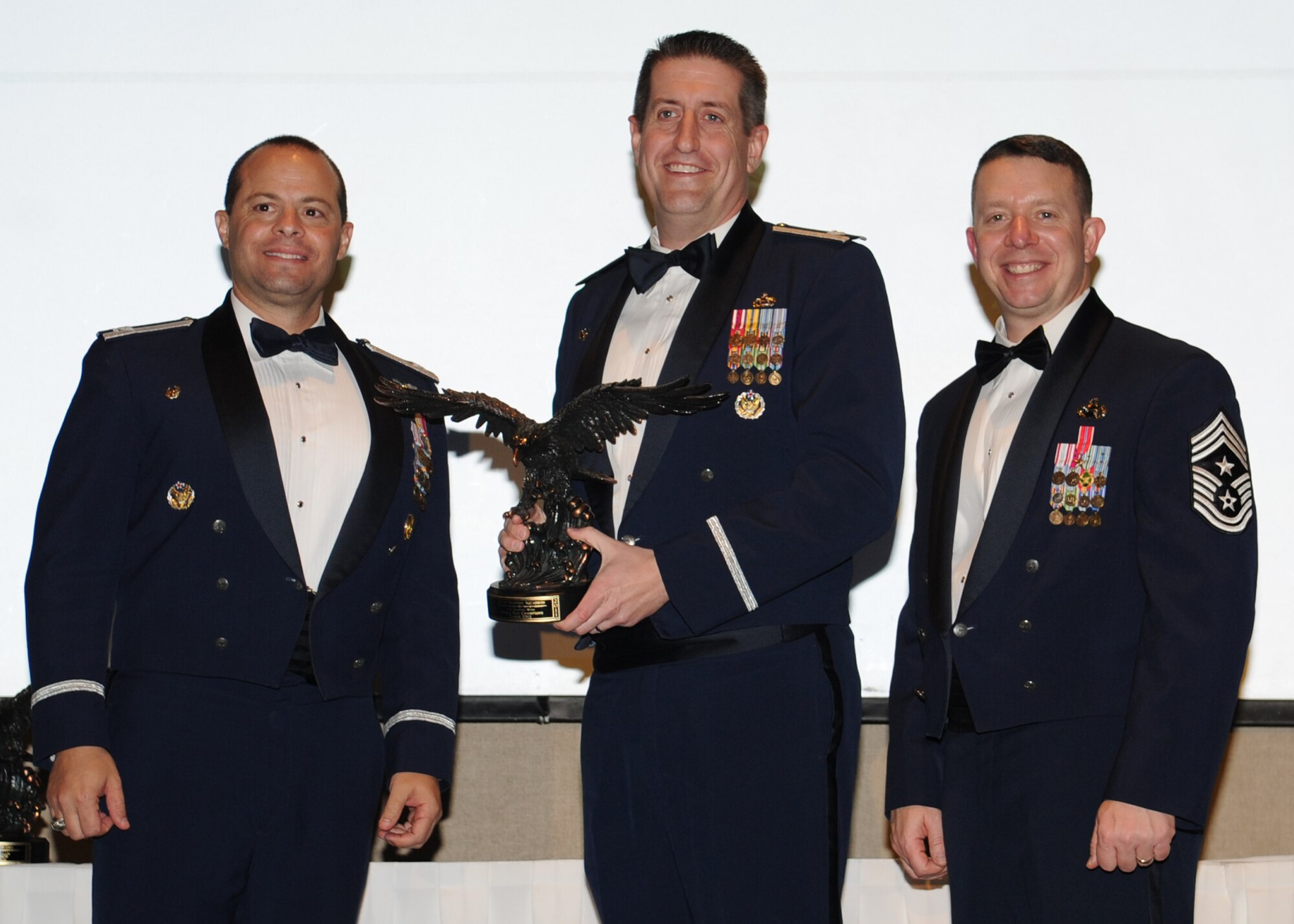 GOODFELLOW AIR FORCE BASE, Texas -- Lt. Col. Christopher Huisman, 315th Training Squadron Commander, accepts the 17th Training Wing 2011 Sports Day trophy for the large squadron on behalf of the 315th TRS from Col. Mark Damiano, 17th TRW Commander, and Chief Master Sgt. Brendan Criswell, 17th TRW Command Chief. The annual awards program recognizes military and civilian personnel who compete in 25 categories for their significant contributions to the 17th TRW, the community and the mission. (U.S. Air Force photo/Staff Sgt. Laura R. McFarlane) 
