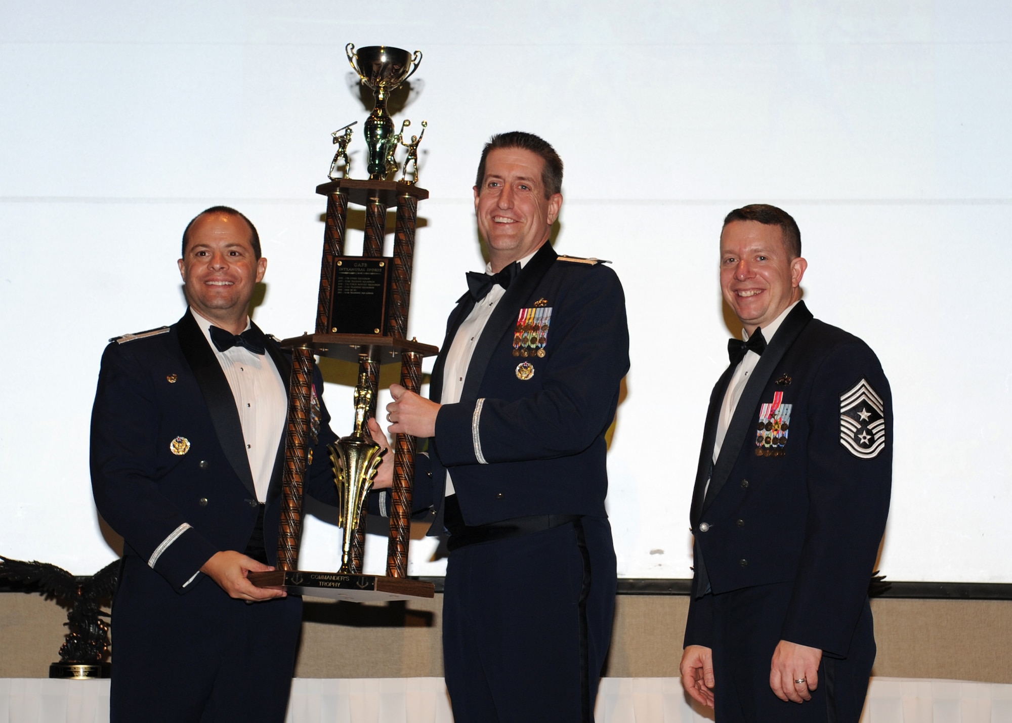 GOODFELLOW AIR FORCE BASE, Texas -- Lt. Col. Christopher Huisman, 315th Training Squadron Commander, accepts the 17th Training Wing 2011 Commanders’ Cup on behalf of the 315th TRS from Col. Mark Damiano, 17th TRW Commander, and Chief Master Sgt. Brendan Criswell, 17th TRW Command Chief. The annual awards program recognizes military and civilian personnel who compete in 25 categories for their significant contributions to the 17th TRW, the community and the mission. (U.S. Air Force photo/ Staff Sgt. Laura R. McFarlane) 