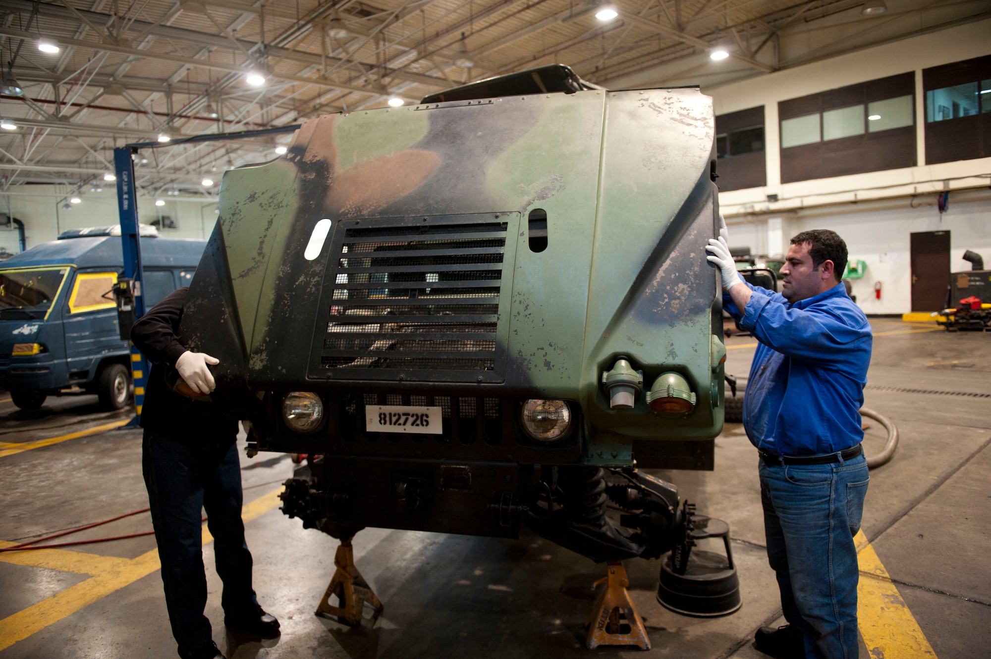 Aykut Kuralay, left, and Cumhur Varkal, 39th Logistics Readiness Squadron, attach a hood to a Humvee Jan. 26, 2012, at Incirlik Air Base, Turkey. Vehicle maintenance performs maintenance on all U.S. government motor vehicles and equipment assigned to Incirlik. They perform scheduled inspections and services, preventive maintenance and any repairs required to maintain the vehicle or equipment in a safe and serviceable condition. (U.S. Air Force photo by Senior Airman Clayton Lenhardt/Released)