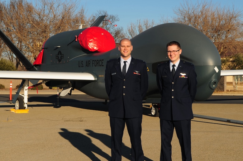 Second Lieutenants Scott (right) and Jacob (left) pose in front of an RQ-4 Global Hawk at the Beale AFB, Calif., flight line Jan. 13, 2012. Lieutenants Jacob and Scott became the first 18X pilots in the Air Force to complete RQ-4 Global Hawk training and were honored during a winging ceremony at the 1st Reconnaissance Squadron’s Dively Theater. (U.S. Air Force photo by Senior Airman Shawn Nickel/Released/Portions of this photo have been masked due to operational security reasons)