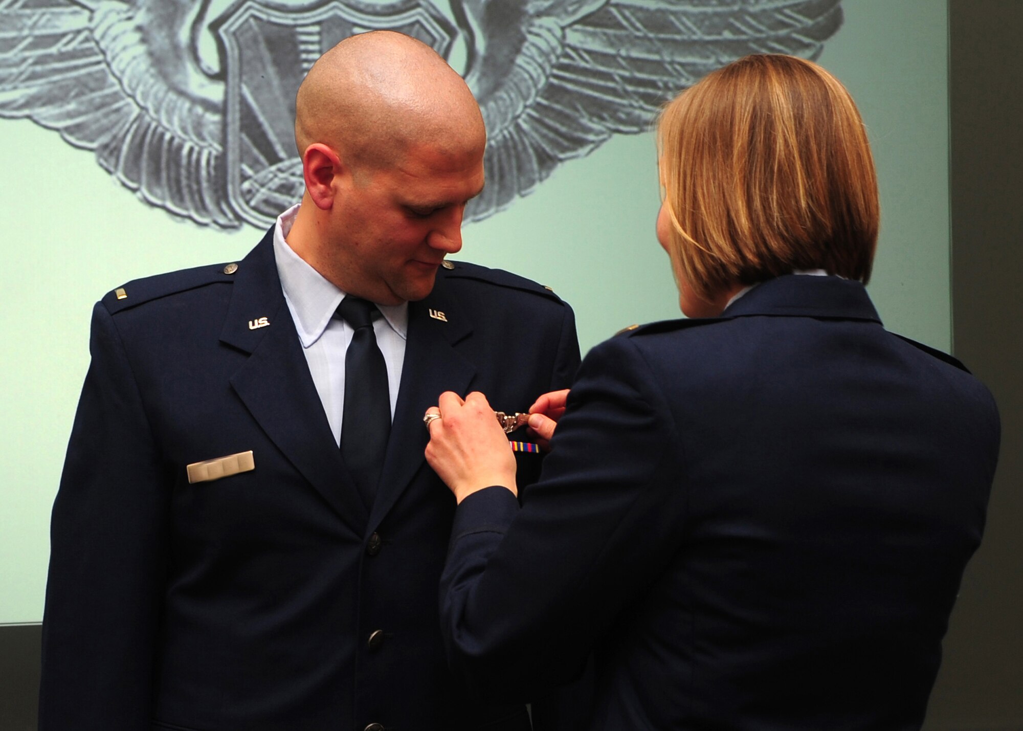 Second Lieutenant Jacob receives his remotely piloted aircraft wings from his wife, 2nd Lt. Rachael, during a winging ceremony at the 1st Reconnaissance Squadron's Dively Theater, Beale AFB, Calif., Jan. 13, 2012. 2nd Lt. Jacob, along with 2nd Lt. Scott, was one of the first two RQ-4 Global Hawk pilots to join the new 18X career field. (U.S. Air Force photo by Senior Airman Shawn Nickel/Released/Portions of this photo have been masked due to operational security reasons)