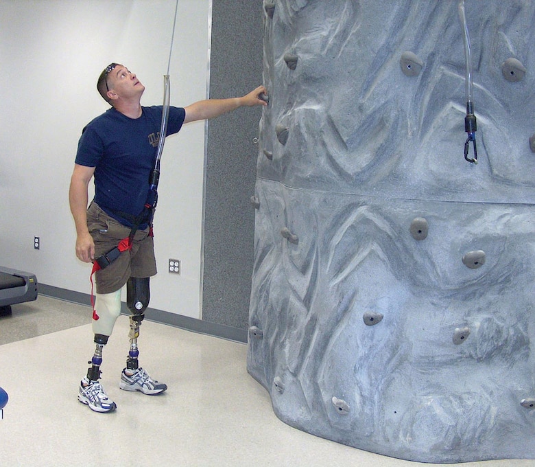 A wounded warrior uses a rock-climbing wall as part of his physical therapy at the Military Advanced Training Center at Walter Reed Army Medical Center.  Soldiers in Warrior in Transition units at Forts Stewart, Benning, Gordon and Bragg now have the option to learn valuable construction and engineering skills as part of Operation Warfighter.