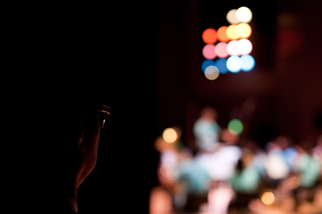 HAMURA CITY, Japan -- Mr. Masato Yagi, Band of the Pacific Asia community relations specialist, watches the performance from the side of the stage during the Japan-U.S. Joint Concert at the Yutorogi Learning Center, Hamura City, Japan, Jan. 28, 2012. Yagi coordinated with the Japanese sponsors to ensure the band's involvement was a sucess. (U.S. Air Force photo/Staff Sgt. Josh Voyles)