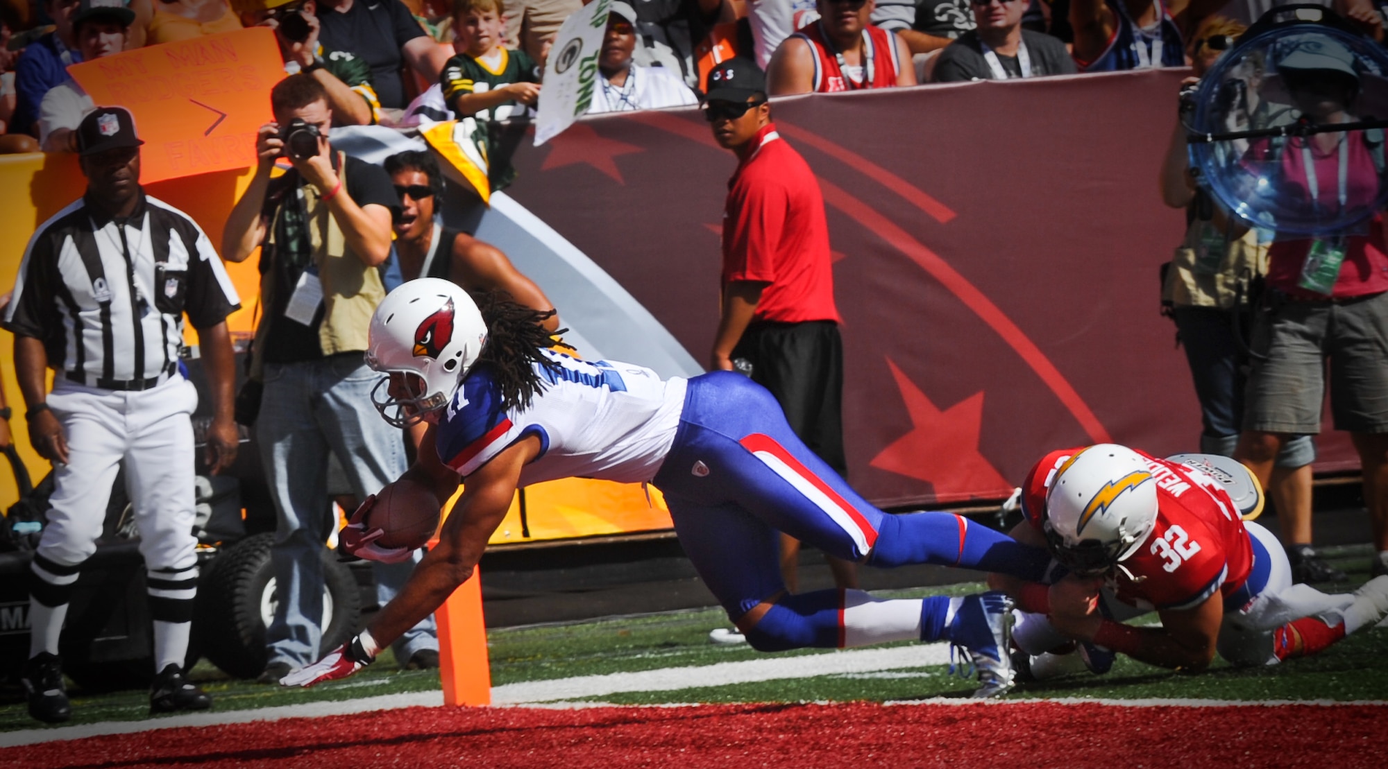 Larry Fitzgerald, wide receiver for the Arizona Cardinals, scores one of three touchdowns during the 2012 Pro Bowl at the Aloha Stadium in Honolulu, Hawaii, Jan. 29. Eric Weddle, San Diego Chargers free safety, wraps ups Fitzgerald's legs too late. (U.S. Air Force photo/Senior Airman Lauren Main)