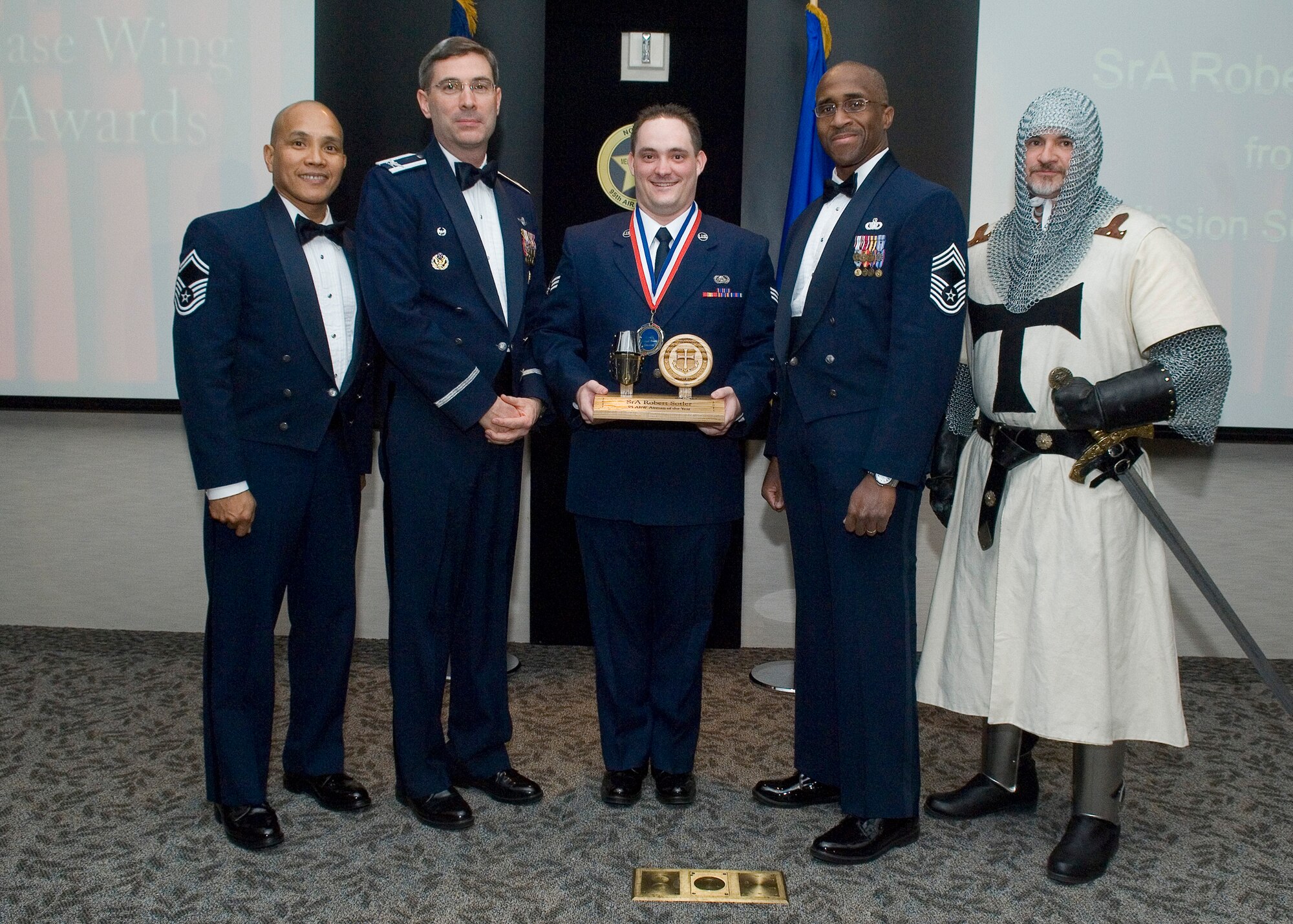 Senior Airman Robert Sotler (center), 95th Communications Squadron, stands with (from left) Senior Master Sgt. Ruel Rafi, 95th CS; Col. Gregory E. Schwab, 95th Air Base Wing commander; Chief Master Sgt. William Green, 95th Security Forces Squadron manager; and Randy Wells as Justin Knight during the 95th ABW Annual Awards Ceremony Jan. 27 in the Conference Center. Sotler was honored with the award for Airman of the Year. (U.S. Air Force photo by Rob Densmore)