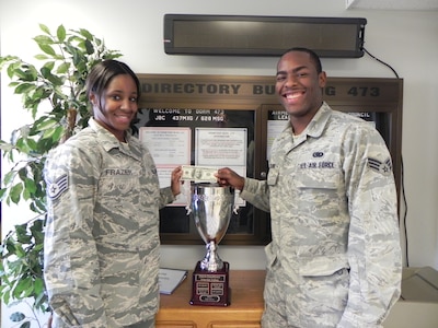 Senior Airman Cory McClure (right) accepts a crisp $100 bill on behalf of Dorm 473, from Staff Sgt. Chiquita Frazier, Jan. 26 at Joint Base Charleston - Air Base. Dorm 473 won the quarterly dorm competition and the Dorm 473 advisory council plans to use the money to benefit the dorm residents. McClure is assigned to the 628th Logistics Readiness Squadron and is the Dorm 473 council president. Frazier is assigned to the 628th Civil Engineer Squadron and is the Dorm 473 Airmen Dorm leader.  (Courtesy photo)