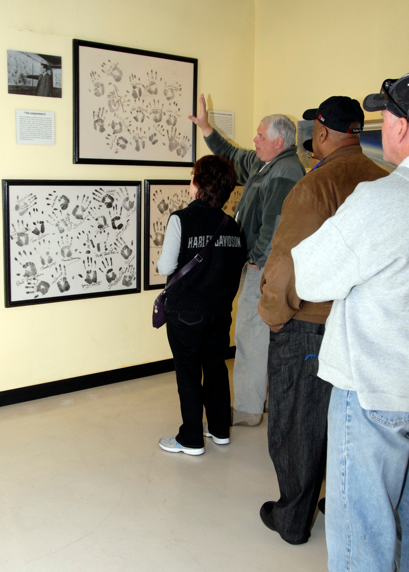 Tony Moore, museum specialist, Air Force Flight Test Center Museum, talks with a tour group about Pancho Barnes and the First Citizen of Edwards Day. During the celebration, Pancho and her closest friends left their handprints and signatures on three panels. The panels were discovered two years ago between the display and exterior museum walls. (U.S. Air Force Photo by Laura Mowry) 
