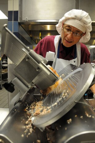 Hoang Truong slices roast pork at the Rainbow Row Galley at board Joint Base Charleston-Weapons Station, Jan. 26. More than 140 Goodwill employees, hired through the AbilityOne program, contribute to the overall success of the five-star rated dining facility by prepping, cooking, cleaning and serving food to service members. The AbilityOne program is a federal initiative that helps people who are blind or have other significant disabilities find employment by working within a national nonprofit agency that sell products and services to the U.S. government. (U.S. Navy photo/Petty Officer 1st Class Jennifer Hudson)