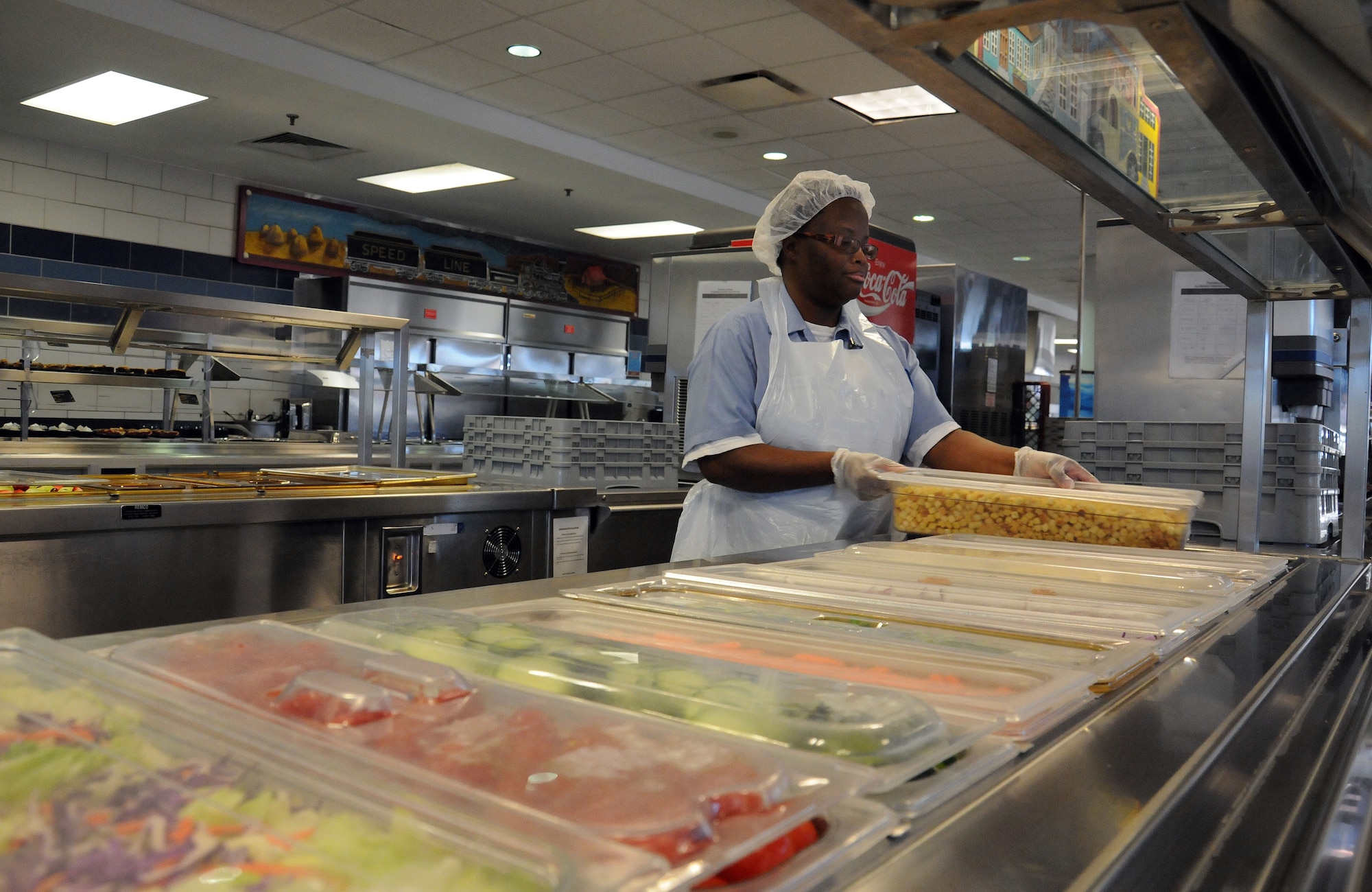 Barbara Pinckney prepares the salad bar prior to the lunch hour at the Rainbow Row Galley at Joint Base Charleston-Weapons Station, Jan. 25. More than 140 Goodwill employees, hired through the AbilityOne program, contribute to the overall success of the five-star rated dining facility by prepping, cooking, cleaning and serving food to service members. The AbilityOne program is a federal initiative that helps people who are blind or have other significant disabilities find employment by working within a national nonprofit agency that sell products and services to the U.S. government. (U.S. Navy photo/Petty Officer 1st Class Jennifer Hudson)