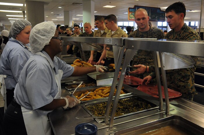 Goodwill employed food service workers serve military members at the Rainbow Row Galley at Joint Base Charleston-Weapons Station, Jan. 26. More than 140 Goodwill employees, hired through the AbilityOne program, contribute to the overall success of the five-star rated dining facility by prepping, cooking, cleaning and serving food to service members. The AbilityOne program is a federal initiative that helps people who are blind or have other significant disabilities find employment by working within a national nonprofit agency which sells products and services to the U.S. government. (U.S. Navy photo/Petty Officer 1st Class Jennifer Hudson)