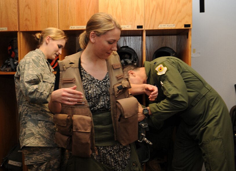 Brittany Pieper, a reporter for KSAL News 12, tries on flight gear after an interview session on Barksdale Air Force Base, La., Jan. 25. Pieper interviewed Airmen assigned here and the 391st Fighter Squadron from Mountain Home Air Force Base, Idaho, on the two-week Green Flag East exercise they participated in from Jan. 12-28. The training exercise helps Airmen from different career fields to prepare for deployments in combat environments. (U.S. Air Force photo/Airman 1st Class Andrew Moua)(RELEASED)