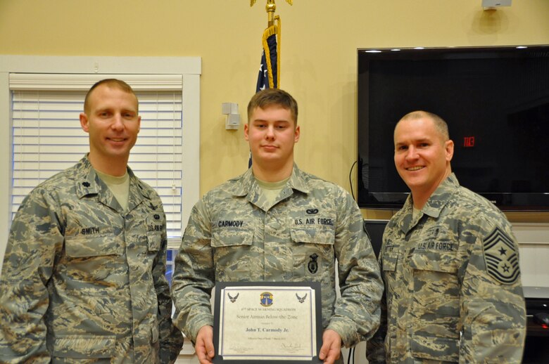 Lt. Col. Shawn Smith (left), 6th Space Warning Squadron commander, and Chief Master Sgt. Thomas Trottier (right), 21st Space Wing command chief, present Airman 1st Class John Carmody a coin and certificate for his recent below the zone promotion to senior airman, Jan. 18 at Cape Cod Air Force Station, Mass. Carmody is a 6th SWS security forces controller from Rutland, Vt. The 6th SWS is one of the 21st SW’s many geographically separated units, and uses the Pave PAWS radar to guard North America's East Coast against sea-launched and intercontinental ballistic missiles. Airmen from Peterson AFB selected for senior airman below the zone include Steven Bernitsky, Emily Maass, Vanessa Butters, Noah Petramala, Jessica Nunez, Steven Hudson, Bon Albana, Donald Thornton and Robert Wellborn. (U.S. Air Force photo/1st. Lt. Keturah Spence)