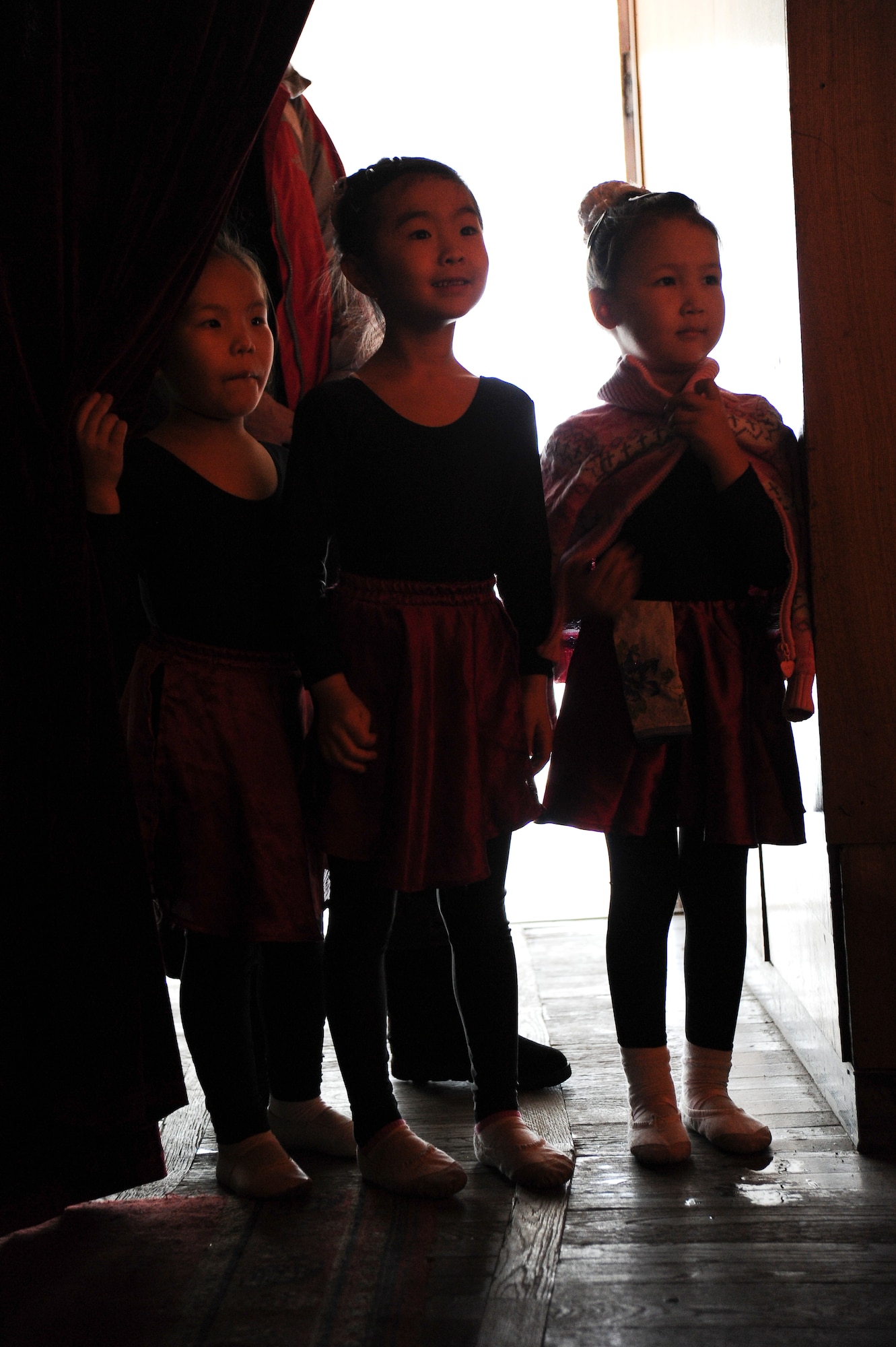 Three young Kyrgyz Republic dance students peek in on the American University of Central Asia's Diversity Week 2012 concert held at the Seitek Youth Center in Bishkek, Kyrgyzstan, Jan. 27, 2012. University students representing 17 different countries performed traditional dances, songs and a little comedic stand-up. They wore customary costumes including decorative headgear.
(U.S. Air Force photo/Master Sgt. Tracy L. DeMarco)
