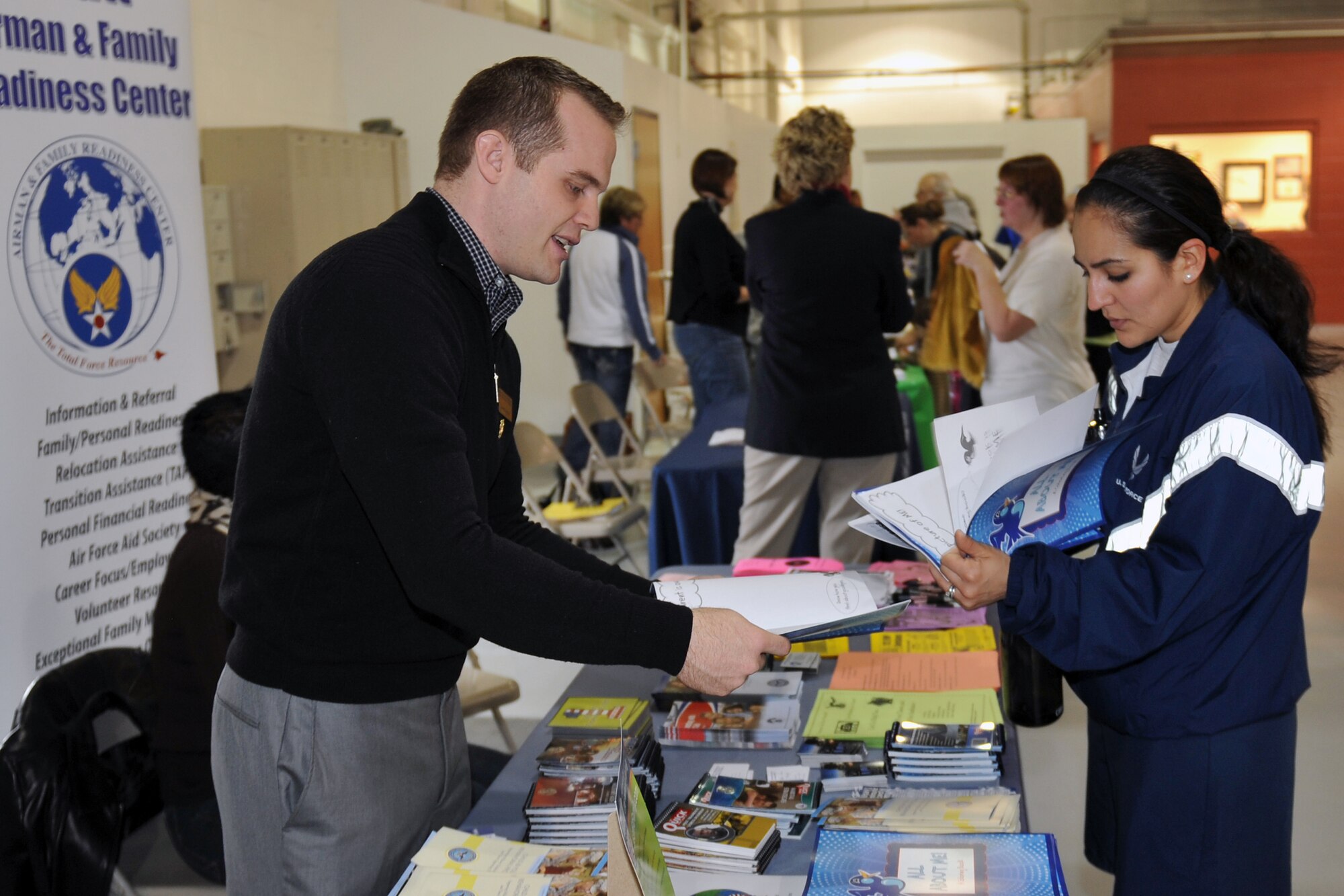 Joseph Heywood, consultant for the Offutt Airman and Family Readiness Center, shows some literature to Staff Sgt. Yaneth Tebo from the 55th Force Support Squadron as part of Resilience Day on Offutt Air Force Base, Neb., Jan. 27. Team Offutt members took part in various activities throughout the base including sporting events at the Offutt Field House. The chief of staff of the Air Force directed a stand down operations for a day to discuss resilience and the wingman concept. (Air Force photo by Jeff Gates/Released)