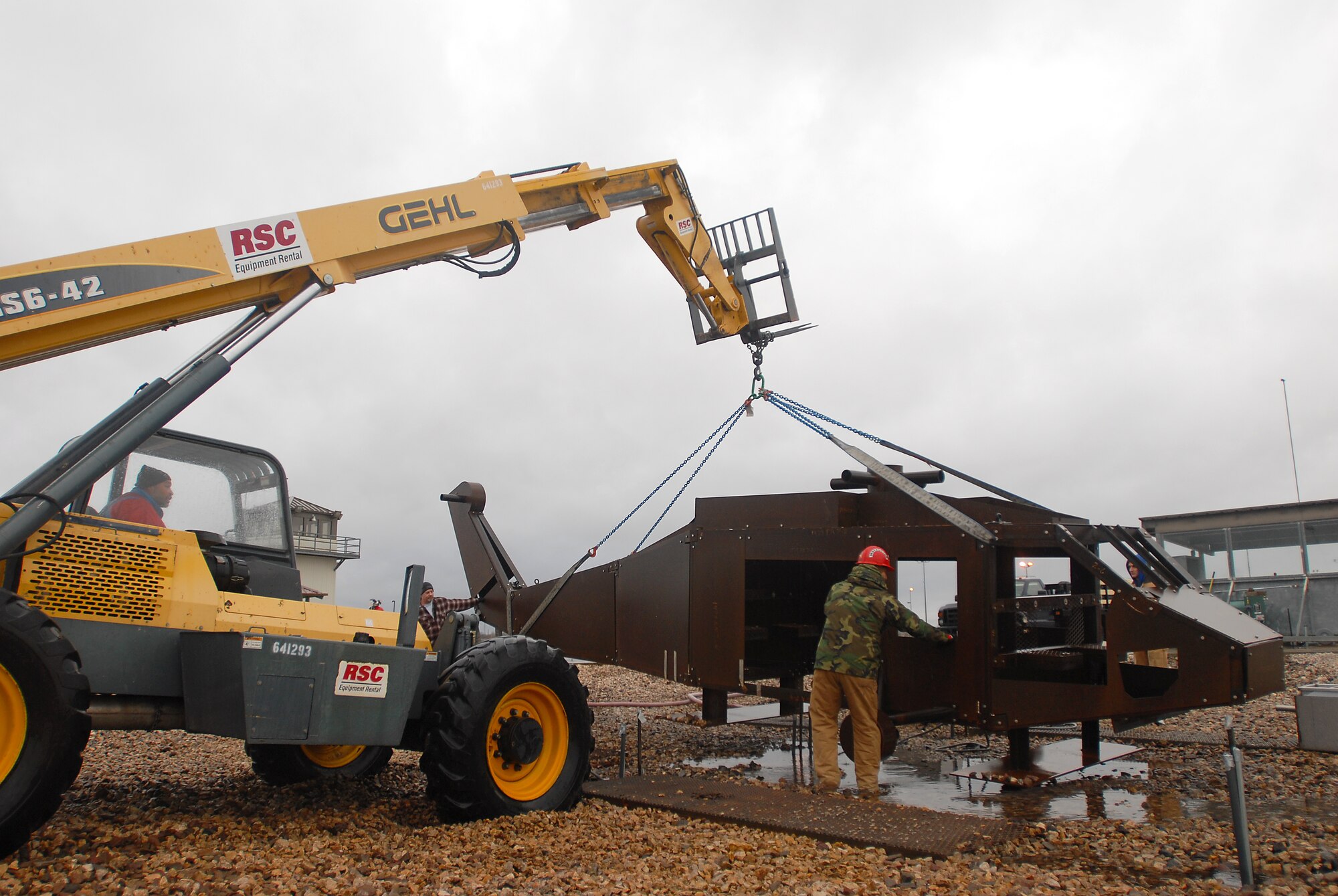 GOODFELLOW AIR FORCE BASE, Texas-- Instructors from the 312th Training Squadron and members of the company Trainer Fabrications from Randolph Air Force Base carefully set a new helicopter trainer into place at Louis F. Garland Fire Academy, here, Jan. 25. The new trainer will be used by students in the sixth block of training to help prepare them to face small aircraft fires in a real-life situation. (U.S. Air Force photo/ Airman 1st Class Michael Smith)