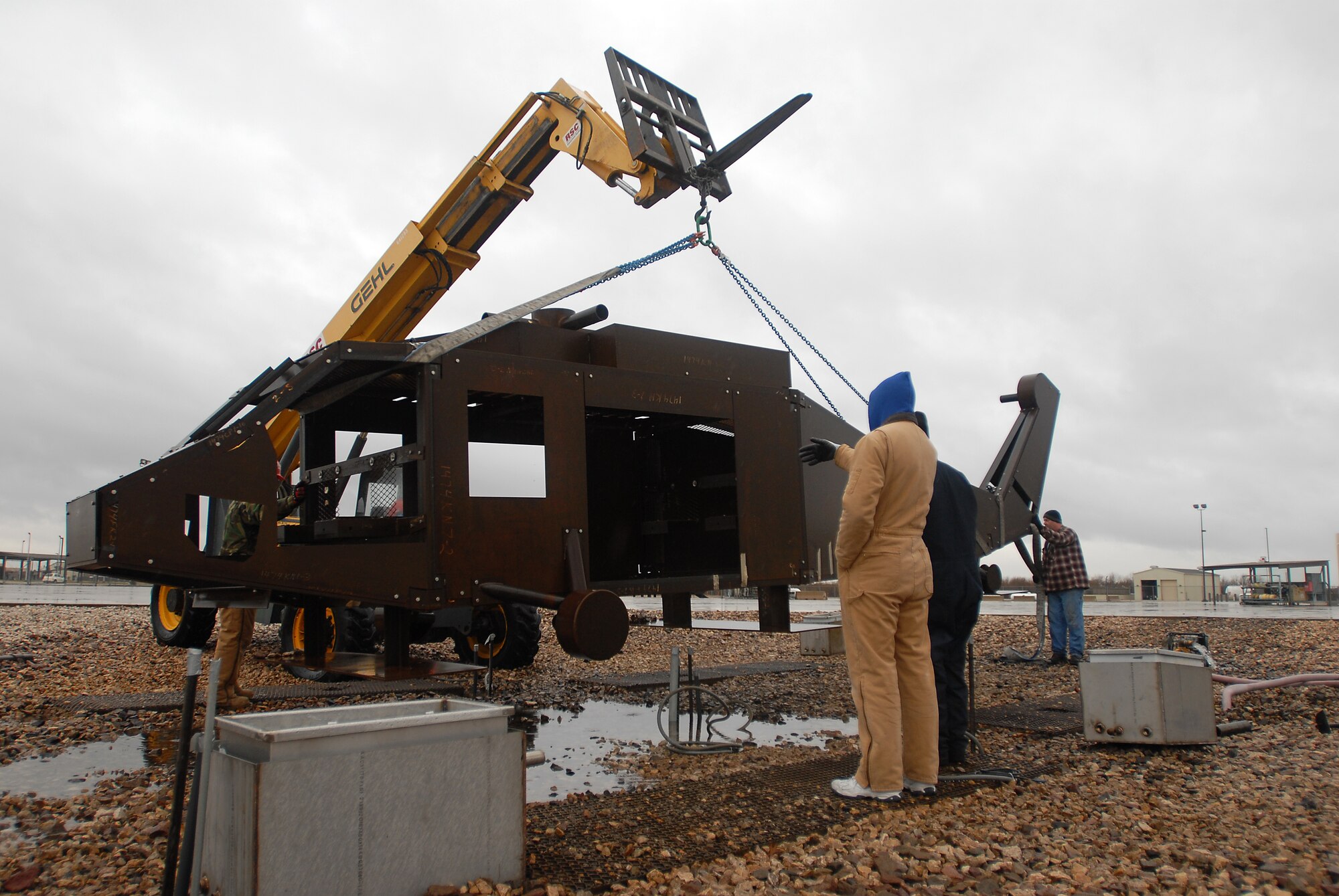 GOODFELLOW AIR FORCE BASE, Texas-- Instructors from the 312th Training Squadron and members of the company Trainer Fabrications from Randolph Air Force Base carefully set a new helicopter trainer into place at Louis F. Garland Fire Academy, here, Jan. 25. The new trainer will be used by students in the sixth block of training to help prepare them to face small aircraft fires in a real-life situation. (U.S. Air Force photo/ Airman 1st Class Michael Smith)