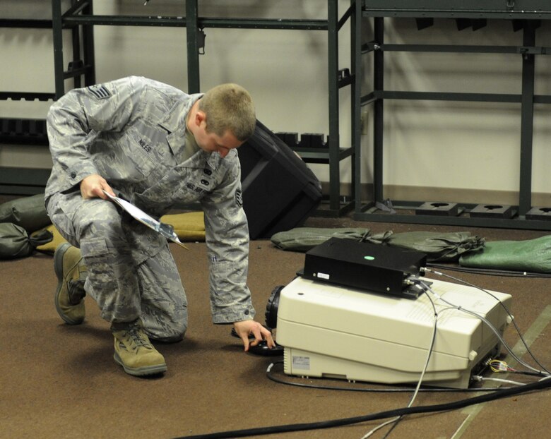 Staff Sgt. Nicholas Niles, 2nd Security Forces Squadron combat arms instructor, turns off a projector connected to a combat training simulator at Barksdale Air Force Base, La., Jan. 30. The combat simulator allows users to train without using live ammunition and paper targets which helps the Air Force save money and resources. (U.S. Air Force photo/Airman 1st Class Micaiah Anthony)(RELEASED)