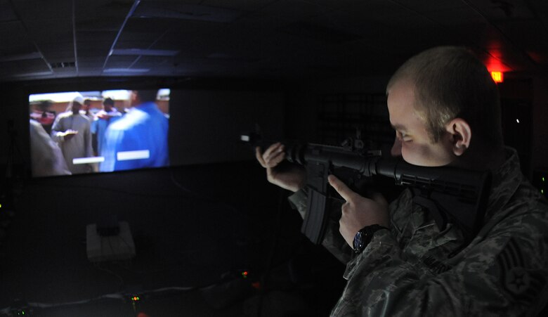 Staff Sgt. Chad Bogaczyk, 2nd Security Forces Squadron combat arms instructor, watches a group approaching his post during a combat training simulation at Barksdale Air Force Base, La., Jan. 30. The combat training simulator allows instructors to help Airmen with their shooting techniques and prepares them for real-world scenarios. (U.S. Air Force photo/Airman 1st Class Micaiah Anthony)(RELEASED)