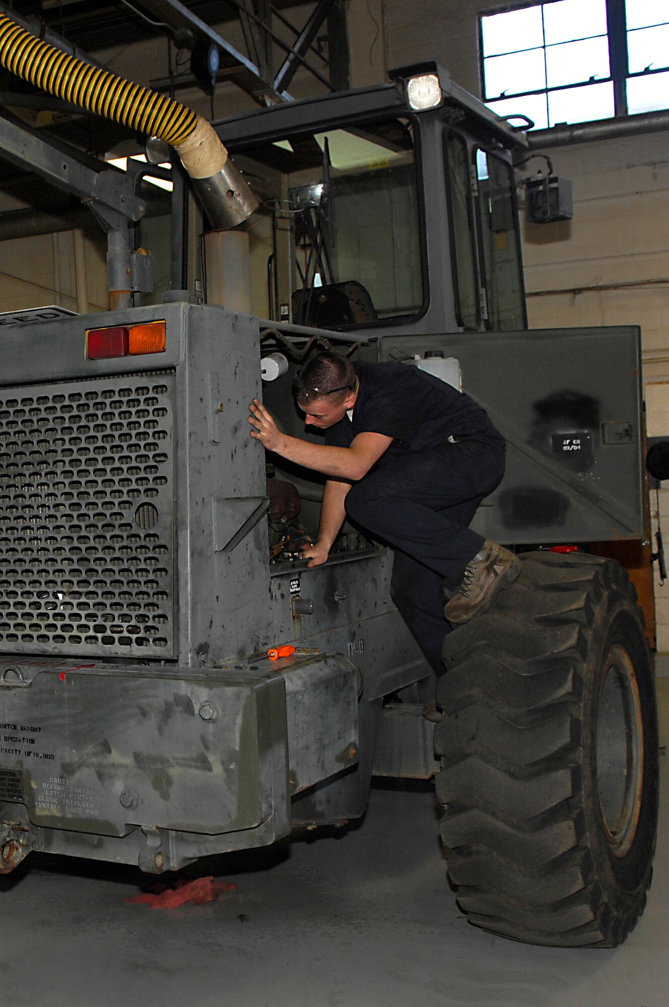 U.S. Air Force Airman 1st Class Christopher Beard, 20th Logistics Readiness Squadron, vehicle mechanic looks inside a tractor during a training exercise, Shaw Air Force Base, S.C., Jan.26, 2012. Training is critical for vehicle operations, as well as other career fields in order to maintain the highest standards for mission readiness. (U.S. Air Force photo by Airman 1st Class Ashley L. Gardner/Released)