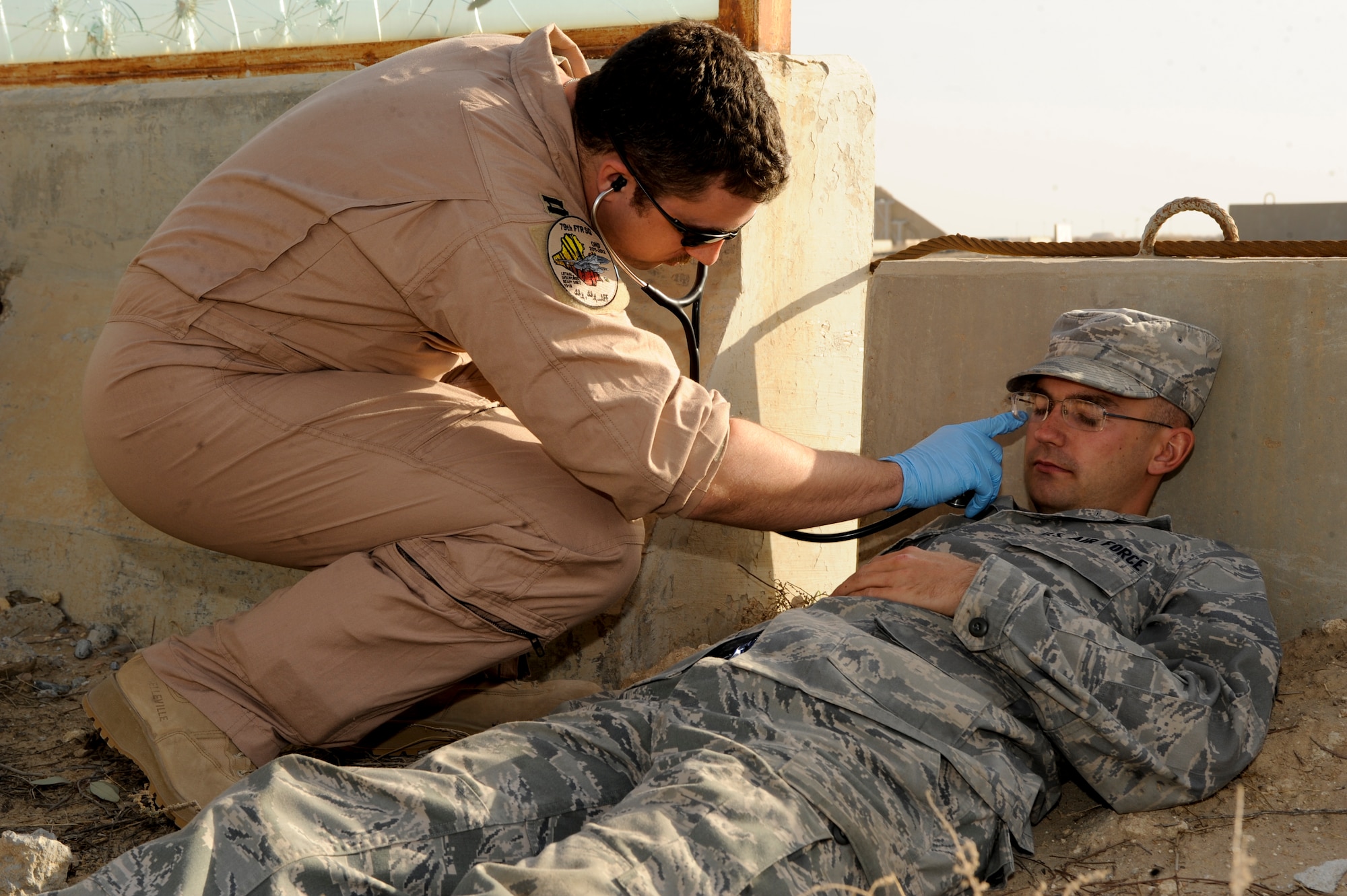 Capt. Adam Heisinger, 332nd Medical Group flight doctor, checks for signs of life on a simulated victim during a mass casualty exercise at an undisclosed location in Southwest Asia, Jan. 30, 2012. Heisinger ensured victims in the scenario had no ‘signs of life’ before marking their time of simulated death. Heisinger is deployed from Shaw Air Force Base, S.C., and is a native of Huron, S.D. (U.S. Air Force photo by Staff Sgt. Joshua J. Garcia/Released)