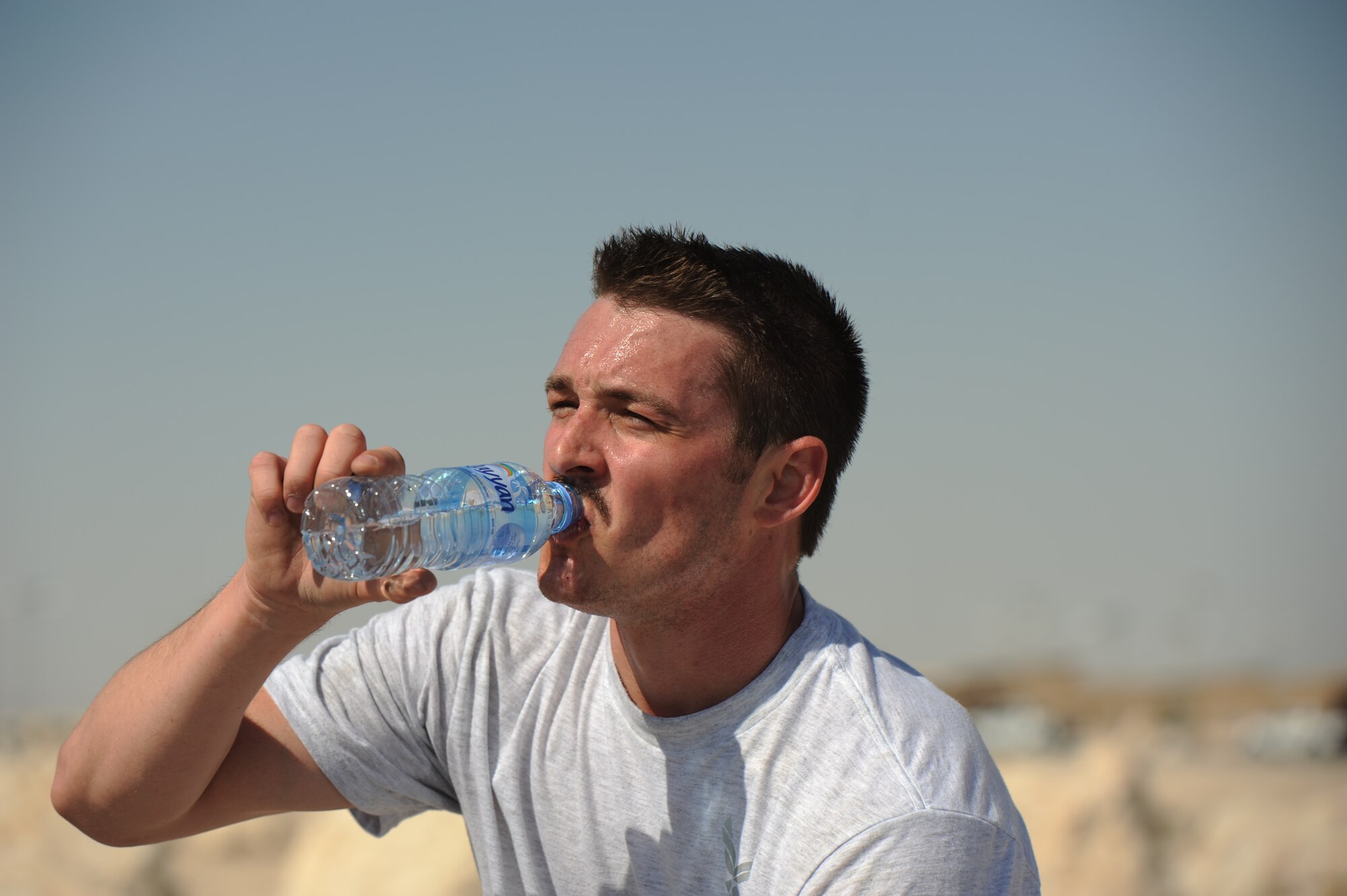 SOUTHWEST ASIA – First Lt. Will Rexer, 340th Expeditionary Air Refueling Squadron and native of Perrysburg, Ohio, drinks water after working out here Jan. 27, 2012. Staff Sgt. Roberto Salinas created a new fitness program that incorporates gymnastics, power lifting and plyometrics to give service members a unique workout. (U.S. Air Force photo/Staff Sgt. Nathanael Callon)
