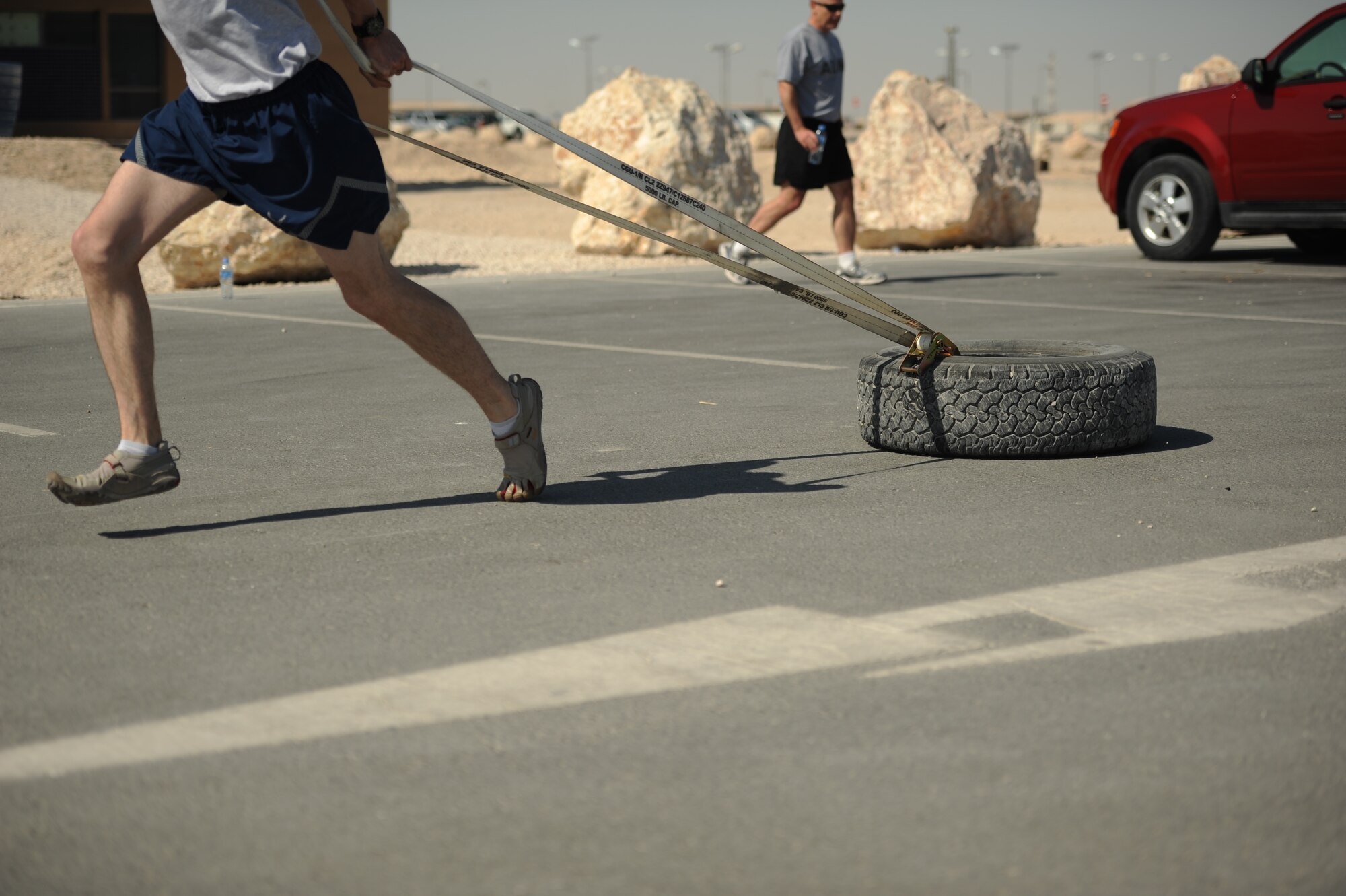 SOUTHWEST ASIA – Senior Airman Brent Borkey, 379th Expeditionary Maintenance Squadron and native of Winston-Salem, N.C., runs 400 meters while dragging a tire during a new fitness program here Jan. 27, 2012. Staff Sgt. Roberto Salinas created a new fitness program that incorporates gymnastics, power lifting and plyometrics to give service members a unique workout. (U.S. Air Force photo/Staff Sgt. Nathanael Callon)
