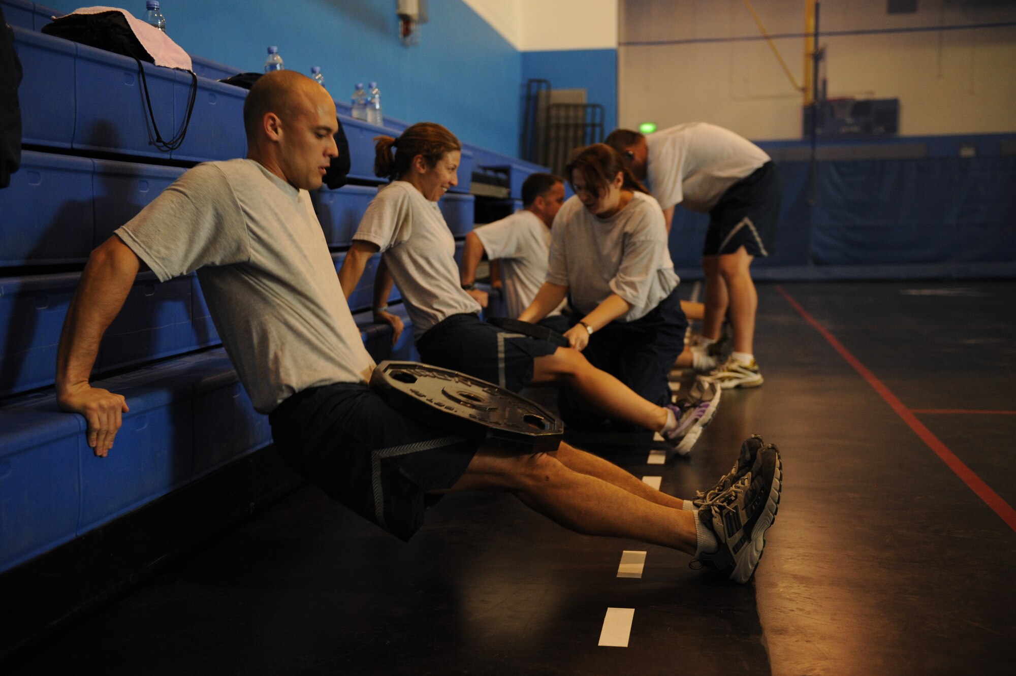 SOUTHWEST ASIA – Airmen from the 379th Air Expeditionary Wing perform dips on the bleachers during a new fitness program here Jan. 27, 2012. Staff Sgt. Roberto Salinas created the program for people who wanted to incorporate a variety of exercises into one fitness regimen. (U.S. Air Force photo/Staff Sgt. Nathanael Callon)