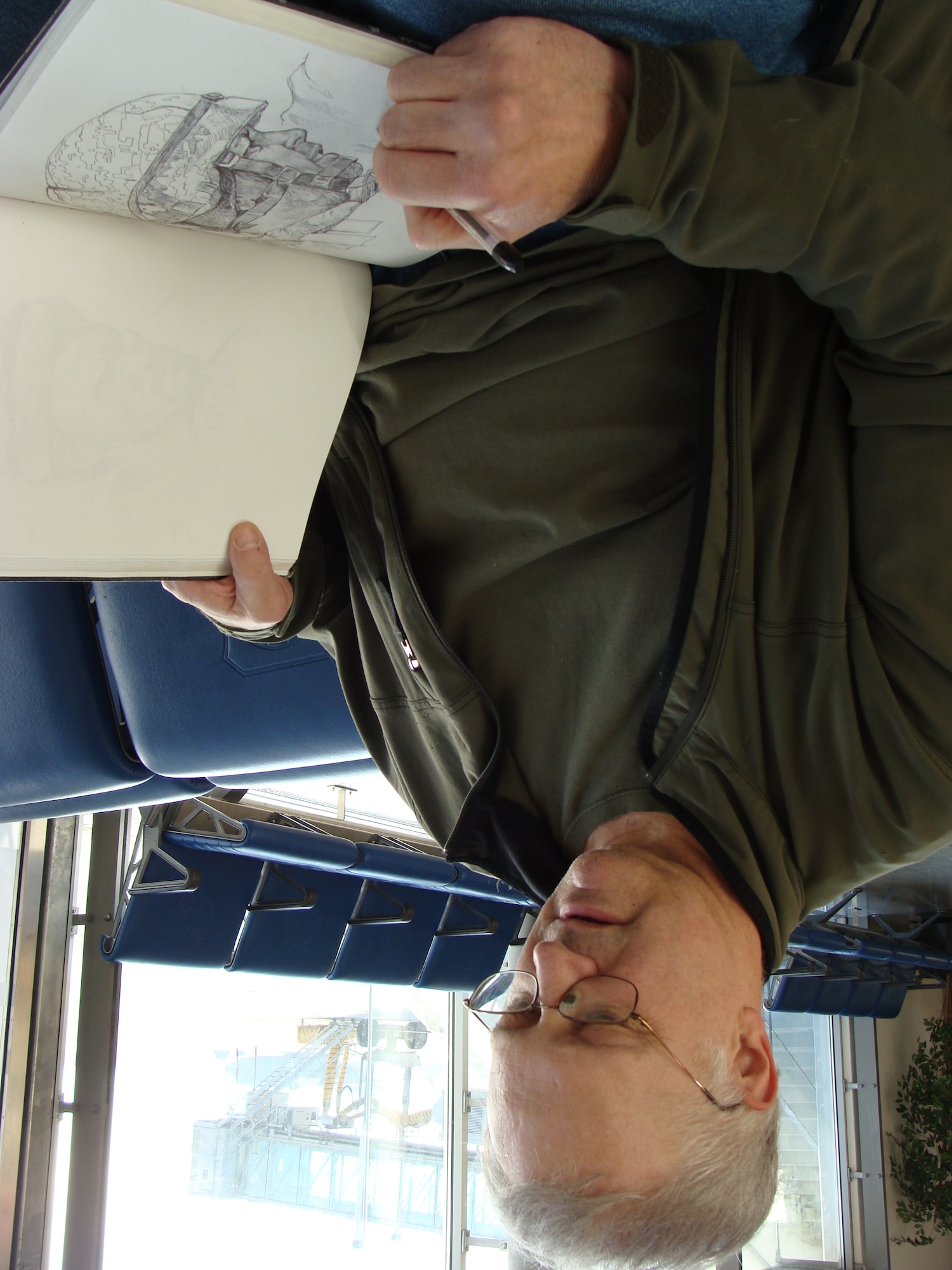 Chris Hopkins, Air Force Art Program artist, puts his finishing touches on a drawing in the Ramstein Passenger terminal. Hopkins was on a trip to document efforts of Airmen in Afghanistan. 
U.S. Air Force photo by Maj. Elizabeth Aptekar
