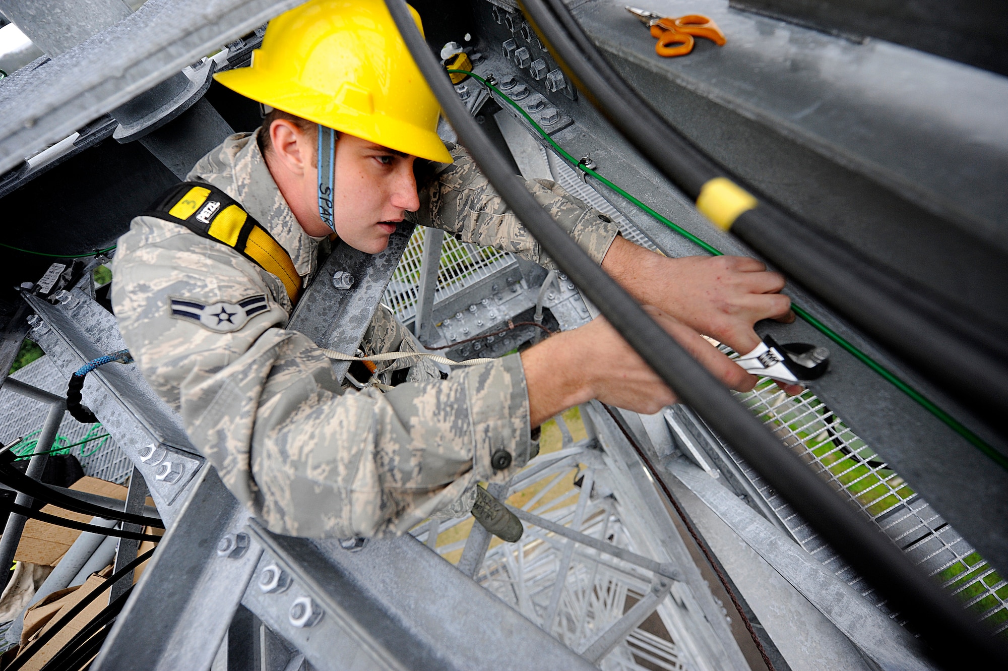 U.S. Air Force Airman 1st Class Joshua Bogenreif, 18th Communications Squadron cable and antenna systems technician, bolts down a wire clamp on an air-to-ground communication transmission tower on Kadena Air Base, Japan, Jan. 30. The 18th CS cable and antenna systems shop has been upgrading the tower since the beginning of the year. (U.S. Air Force photo by Airman 1st Class Maeson L. Elleman/Released)