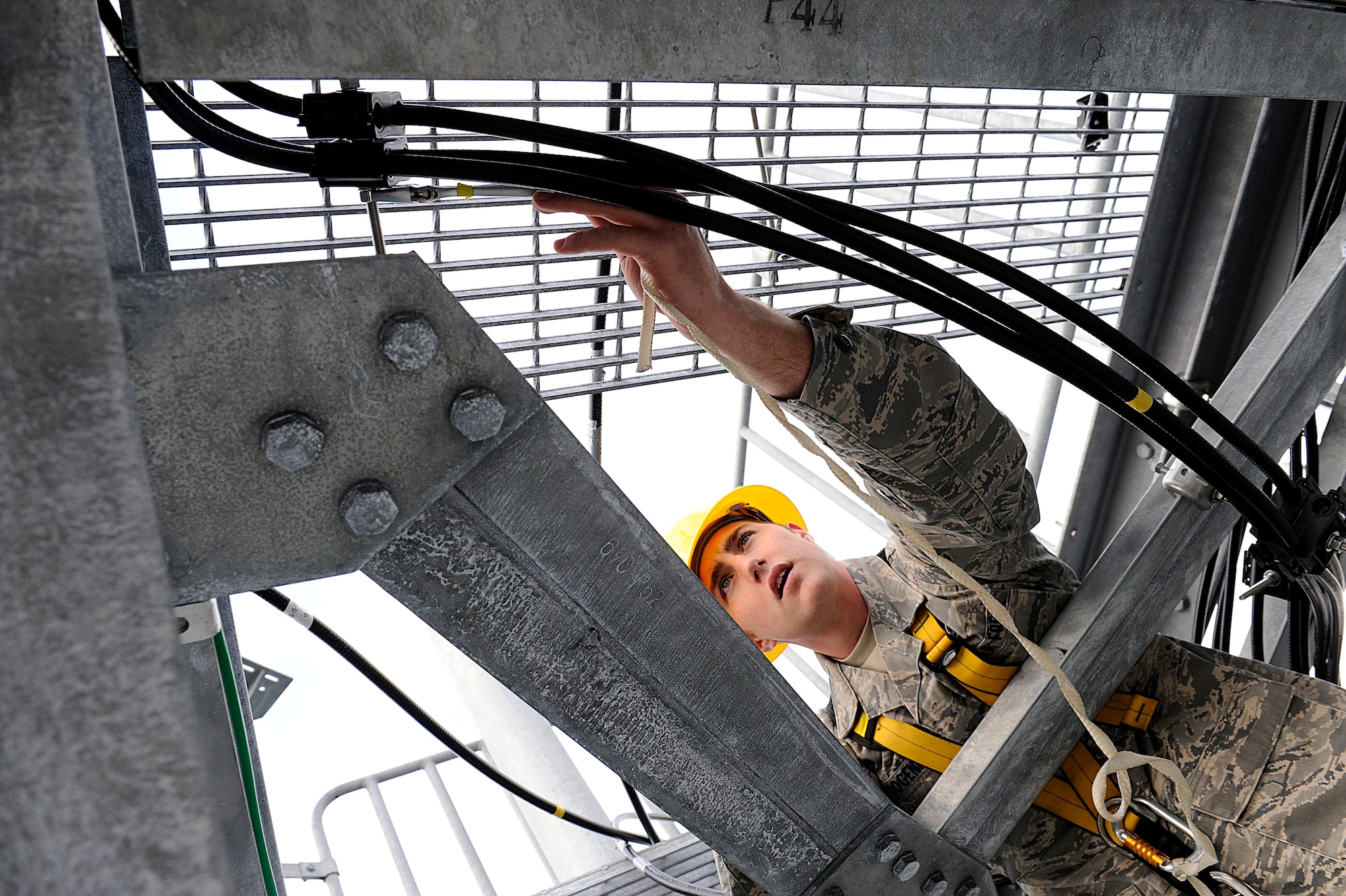 U.S. Air Force Airman 1st Class Joshua Bogenreif, 18th Communications Squadron cable and antenna systems technician, replaces cable clamps on an air-to-ground communication transmission tower on Kadena Air Base, Japan, Jan. 30. The antenna system is receiving a nearly $800,000 upgrade to greatly increase Kadena's aircraft coordination capabilities. (U.S. Air Force photo by Airman 1st Class Maeson L. Elleman/Released)