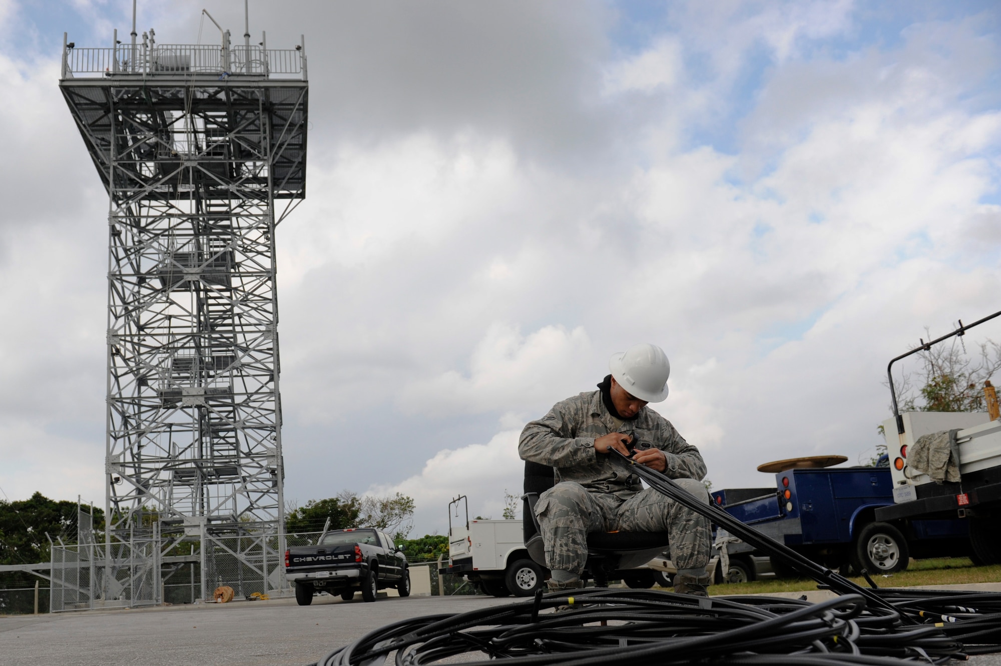 U.S. Air Force Airman 1st Class Jeshod Hughes, 18th Communications Squadron cable and antenna systems technician, uses electrical tape to cover the ends of old cables from an air-to-ground communication transmission tower on Kadena Air Base, Japan, Jan. 30. The 18th CS cable and antenna systems shop has been replacing Kadena's air-to-ground communication antenna towers, the largest in the Pacific Air Forces, since the beginning of the year. (U.S. Air Force photo by Airman 1st Class Maeson L. Elleman/Released)
