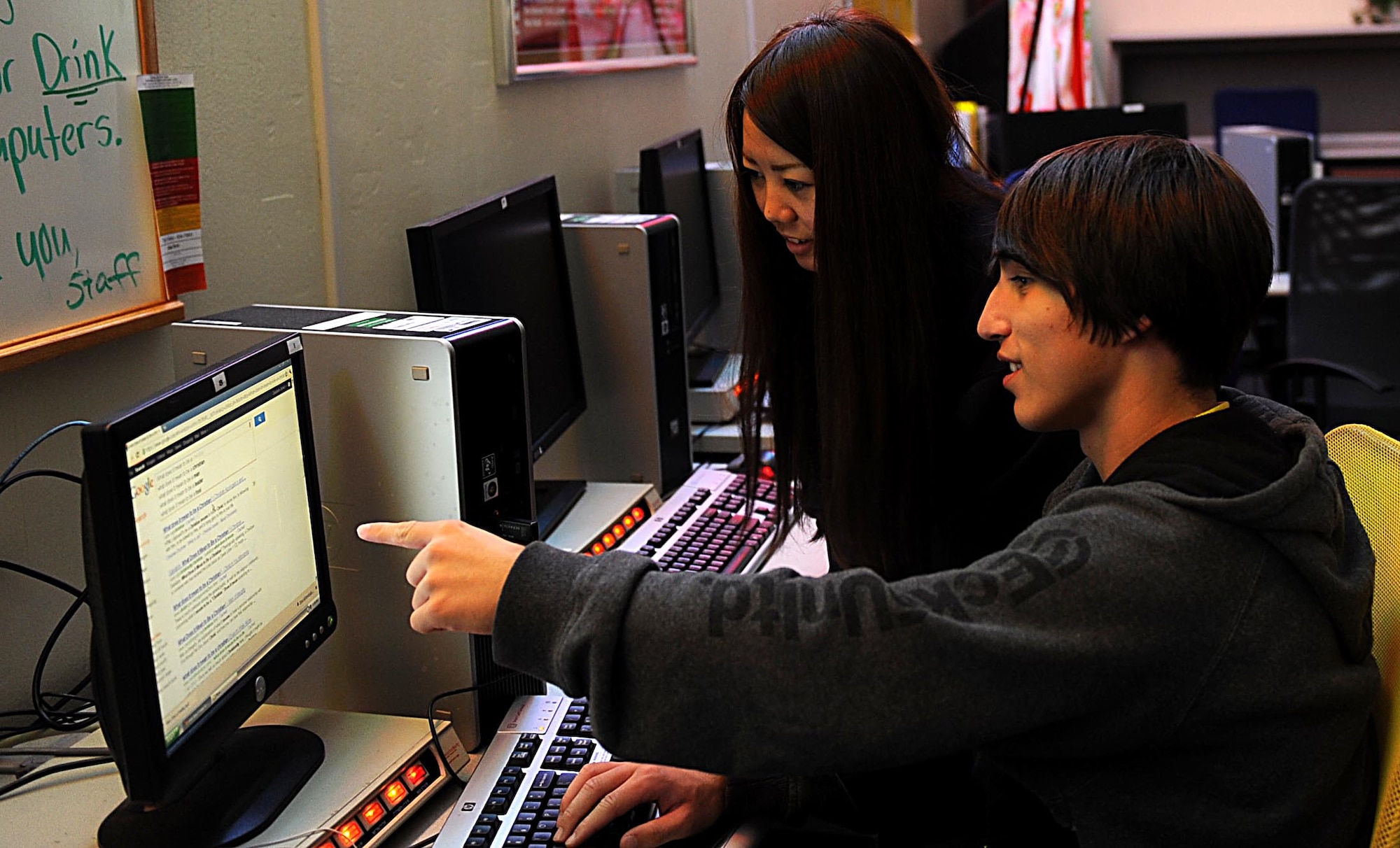 Okinawan intern Airi Kuda, a student at Nikkei College of Business, assists a student at the Nakiyoshi Youth Program Complex on Kadena Air Base, Japan, Jan. 26, 2012. Kuda and 24 other students worked at Kadena from Jan. 16-27 as part of the first internship and shadow program between Kadena, Nikkei College of Business and the Okinawa College of Information and Accounting. (U.S. Air Force photo by Airman 1st Class Brooke P. Beers/Released)