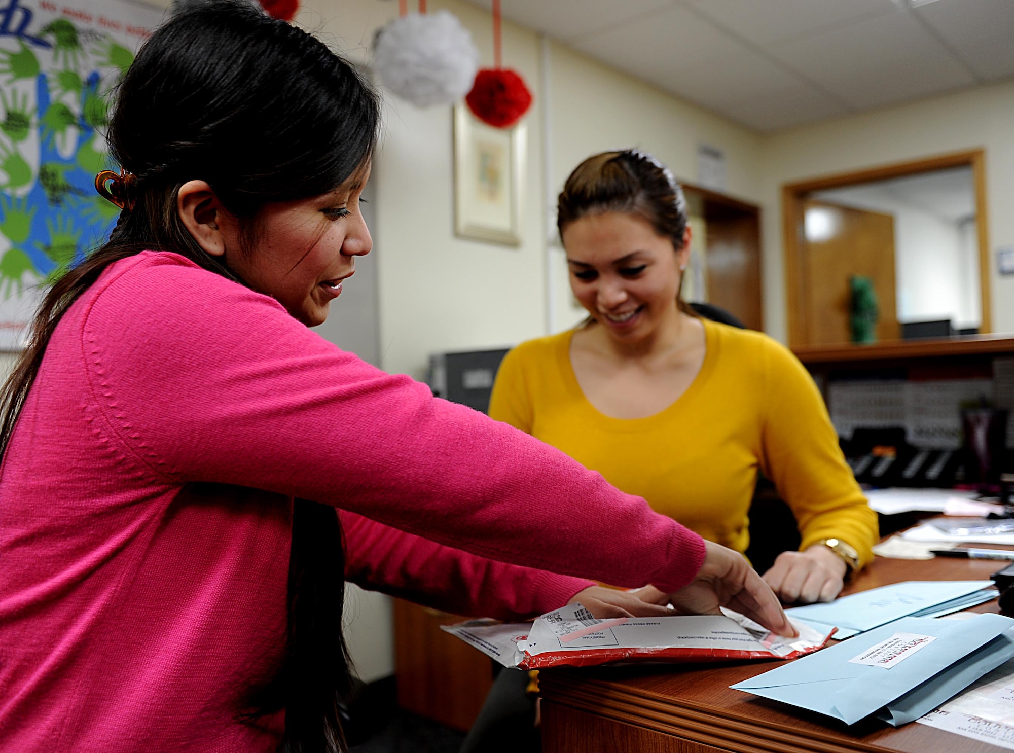 Natalia Hokama, a student with the Okinawa College of Information and Accounting, opens envelops of coupons that are sent daily to the Airman and Family Readiness Center on Kadena Air Base, Japan, Jan. 26, 2012. Hokama worked at the A&FRC for two weeks during an internship program that aims to provide Okinawan students with an opportunity to communicate in English, learn American culture and to experience American-style business. (U.S. Air Force photo by Airman 1st Class Brooke P. Beers/Released)