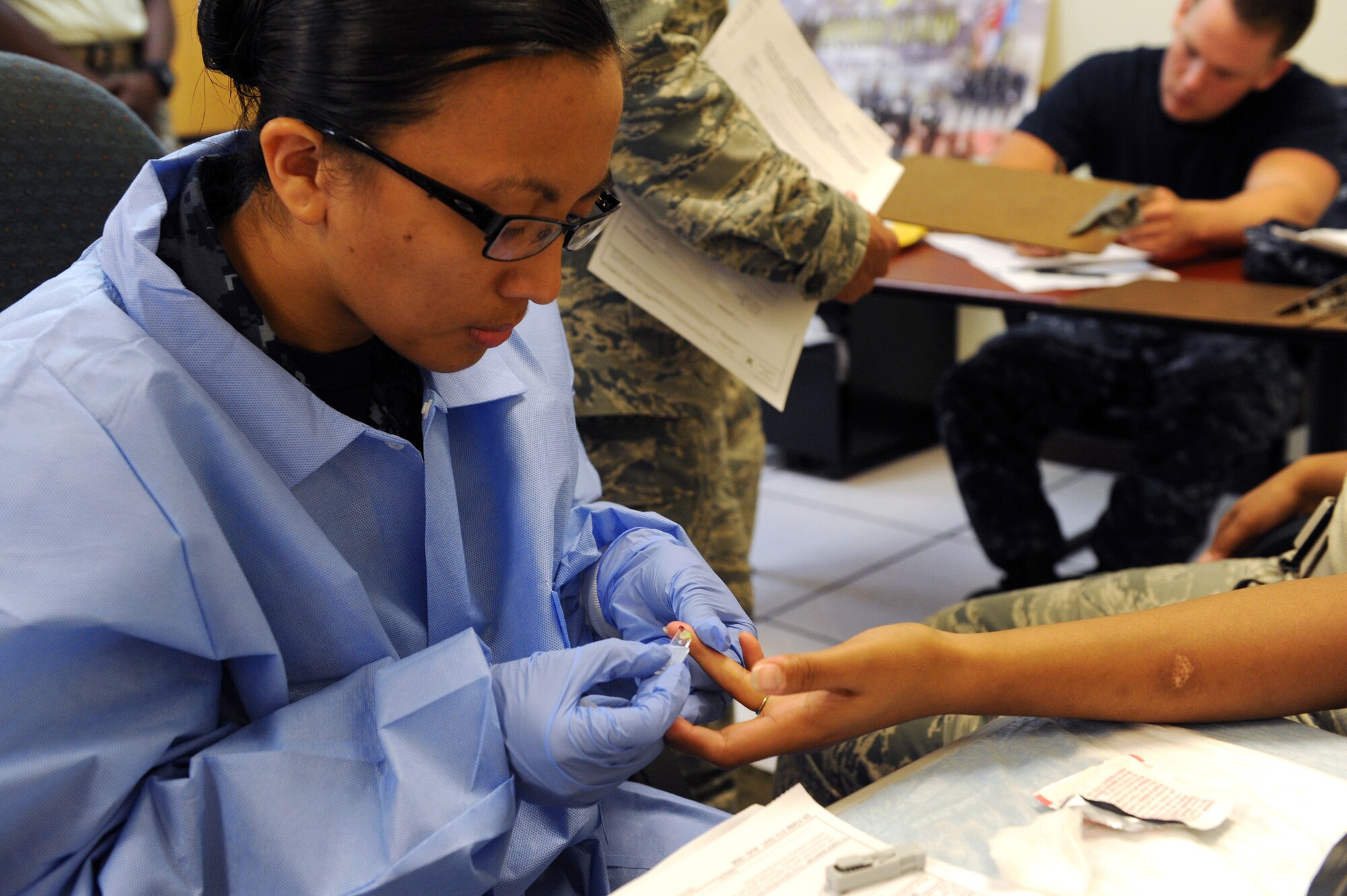 U.S. Navy Petty Officer 2nd Class Joyce Pascual, hospital corpsman from the U. S. Naval Hospital Camp Lester, draws blood from Airman 1st Class Morgan Bivins, 18th Logistics Readiness Squadron First-Term Airman Center student, during the blood drive on Kadena Air Base, Japan, June 27, 2012. FTAC has supported the Armed Forces Blood Donor program since January 2007 with 66 blood drives. The blood donor recruiter from the Armed Services Blood Bank Center and FTAC coordinates and arranges blood drives twice a month. (U.S. Air Force photo/Junko Kinjo)