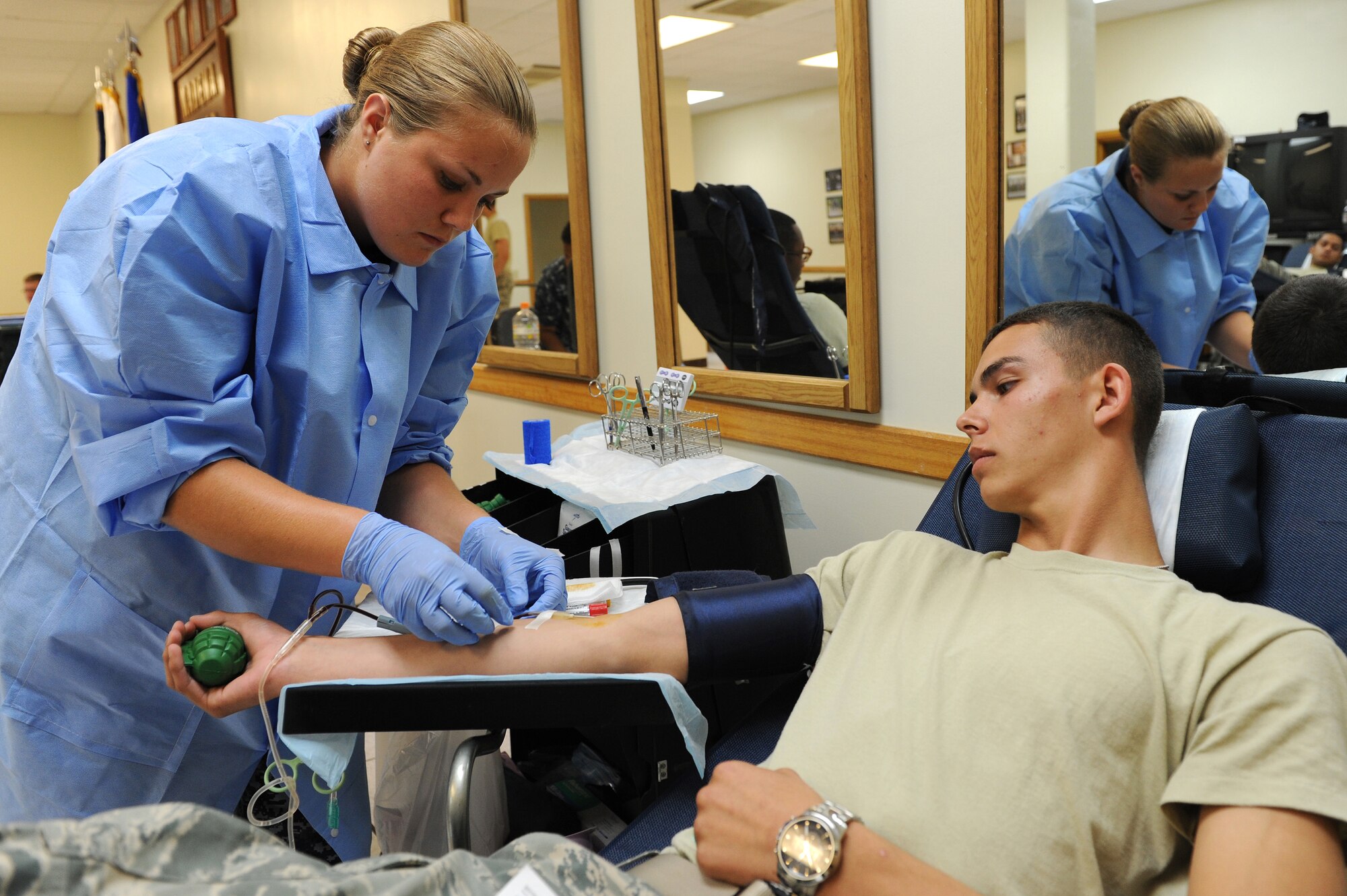 U.S. Navy Seaman Leigh Prevatte, hospital corpsman from the U.S. Naval Hospital Camp Lester, draws blood from Airman 1st Class Devon Deuter, 18th Security Forces Squadron First-Term Airman Center student, during the blood drive on Kadena Air Base, Japan, June 27, 2012. FTAC leads the Pacific with 423 units of blood donated. The blood donations produced 1,269 blood products which have helped support the medical needs of 1,269 patients throughout Pacific Air Forces. (U.S. Air Force photo/Junko Kinjo)