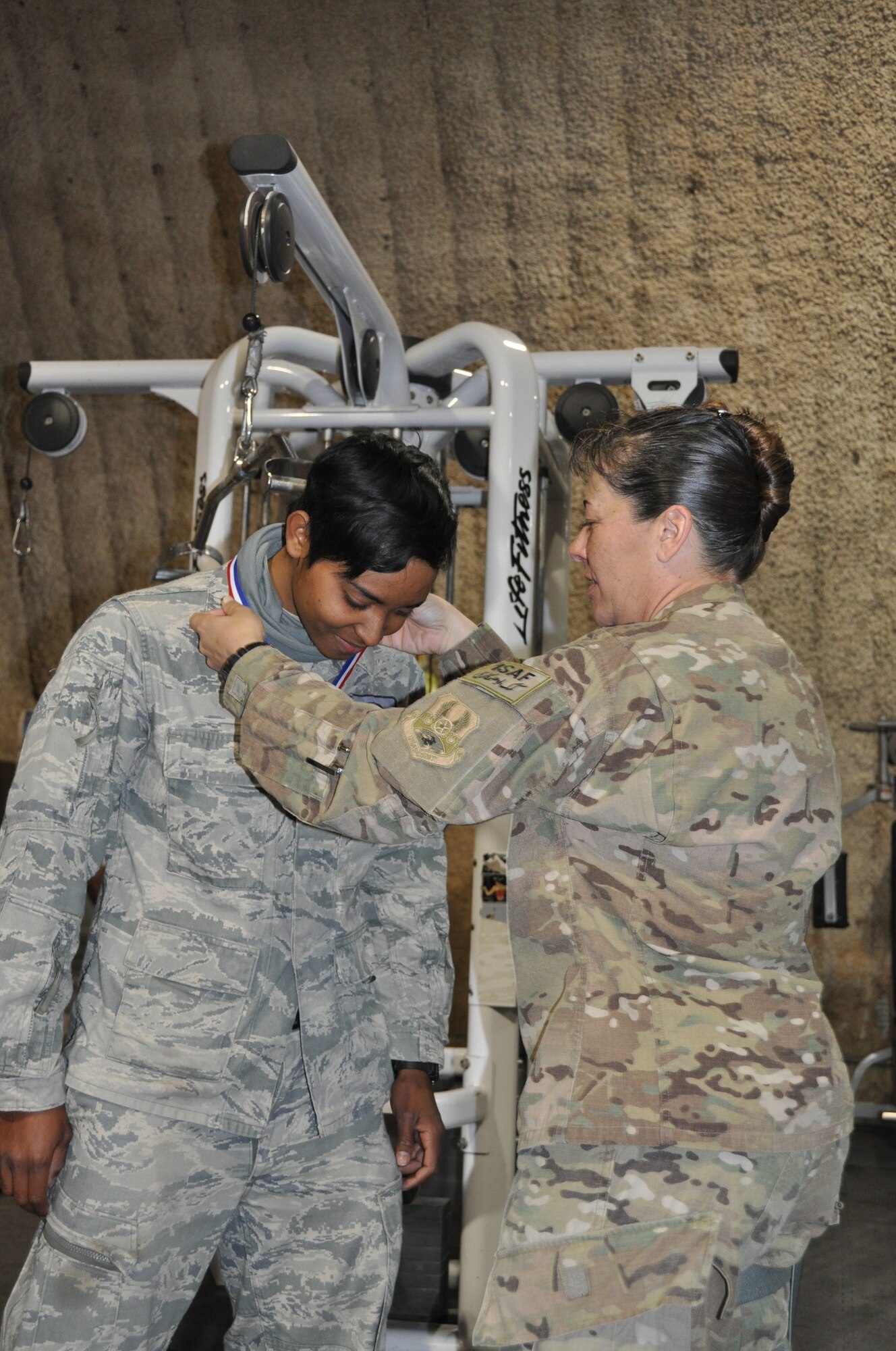 Lt Col Katrina Stephens (right), 455th Expeditionary Force Support Squadron commander, presents the "strongest in the AOR" 1st place medal for females to SrA Melanie Harris, assigned to 455th Expeditionary Civil Engineer Squadron at Bagram Airfield, Afghanistan. Bagram-assigned Airmen recently bested more than 40 competitors from all regional bases to earn the title "strongest in the AOR." (U.S. Air Force photo/TSgt Shawn McCowan)