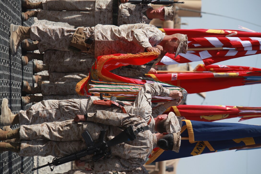 Brig. Gen. John Broadmeadow, center, Commanding General, 1st Marine Logistics Group (Forward), places the Afghanistan Campaign Streamer with two bronze stars to the 1st MLG (Fwd) organizational colors during the 1st MLG’s 65th Anniversary ceremony at Camp Leatherneck, Afghanistan, July 2. During the ceremony, Brig. Gen. Broadmeadow spoke to the Marines and sailors about 1st MLG’s legacy.