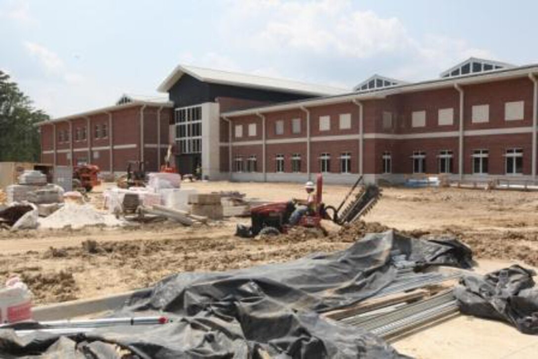 Construction workers work at the Wallace Creek Fitness Center aboard Marine Corps Base Camp Lejeune. The fitness center is nearing completion and is expected to open in September.  