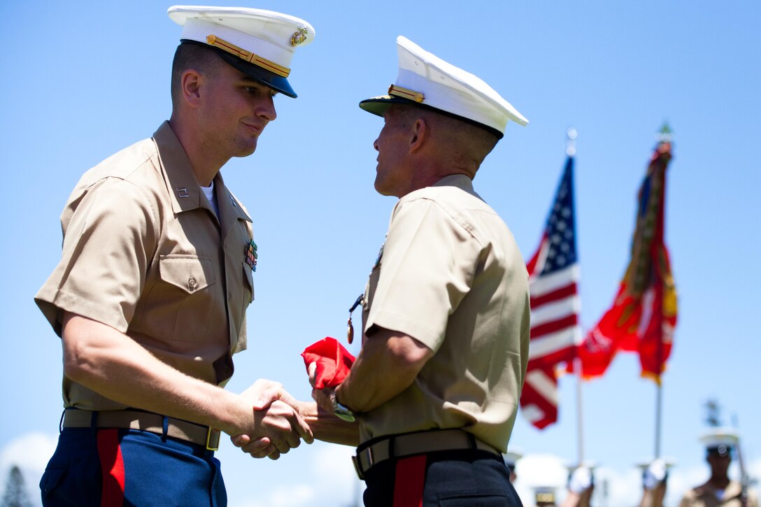 Brig. Gen. Ronald F. Baczkowski, deputy commander of U.S. Marine Corps Forces, Pacific, shares a moment with Capt. Gregory A. Wagner, who served as his aide-de-camp, after being presented his one-star flag here June 29 during his retirement ceremony. “It’s been an honor to work for him,” Wagner said. “He is a phenomenal Marine and person,” adding that Baczkowski still ran a perfect physical fitness test.