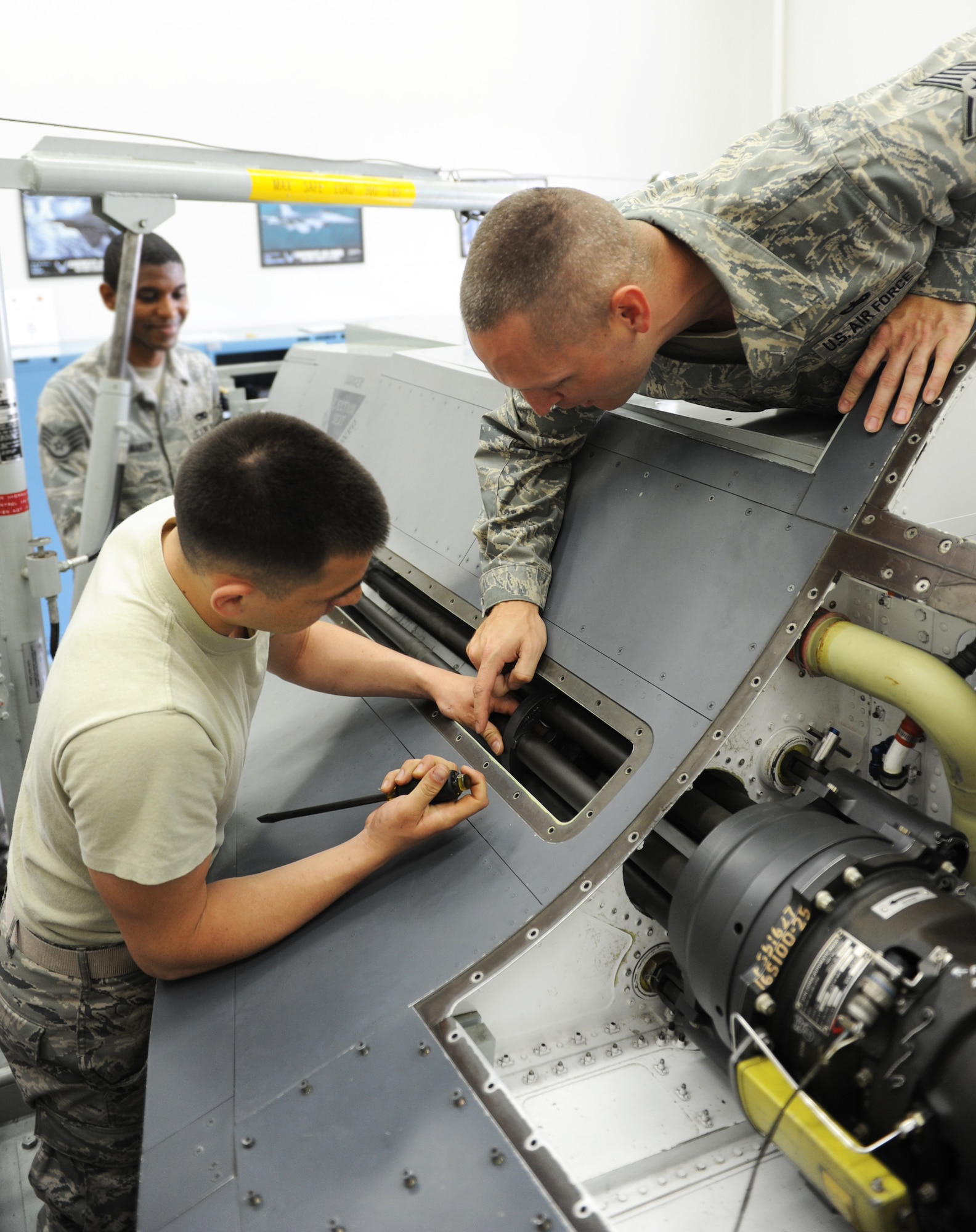 U.S. Air Force Tech. Sgt. Jason Bouse, right, 372nd Training Squadron Detachment 23 F-16 weapons instructor, advises Senior Airman Chris Rodriquez, 35th Aircraft Maintenance Squadron aircraft armament systems, how to install an M61A1 Vulcan cannon on an F-16 trainer during a two-week basic flightline maintenance course at Misawa Air Base, Japan, July 2, 2012. The M61A1 fires standard M50 ammunition at 6,600 rounds per minute. (U.S. Air Force photo by Airman 1st Class Kia Atkins/Released)