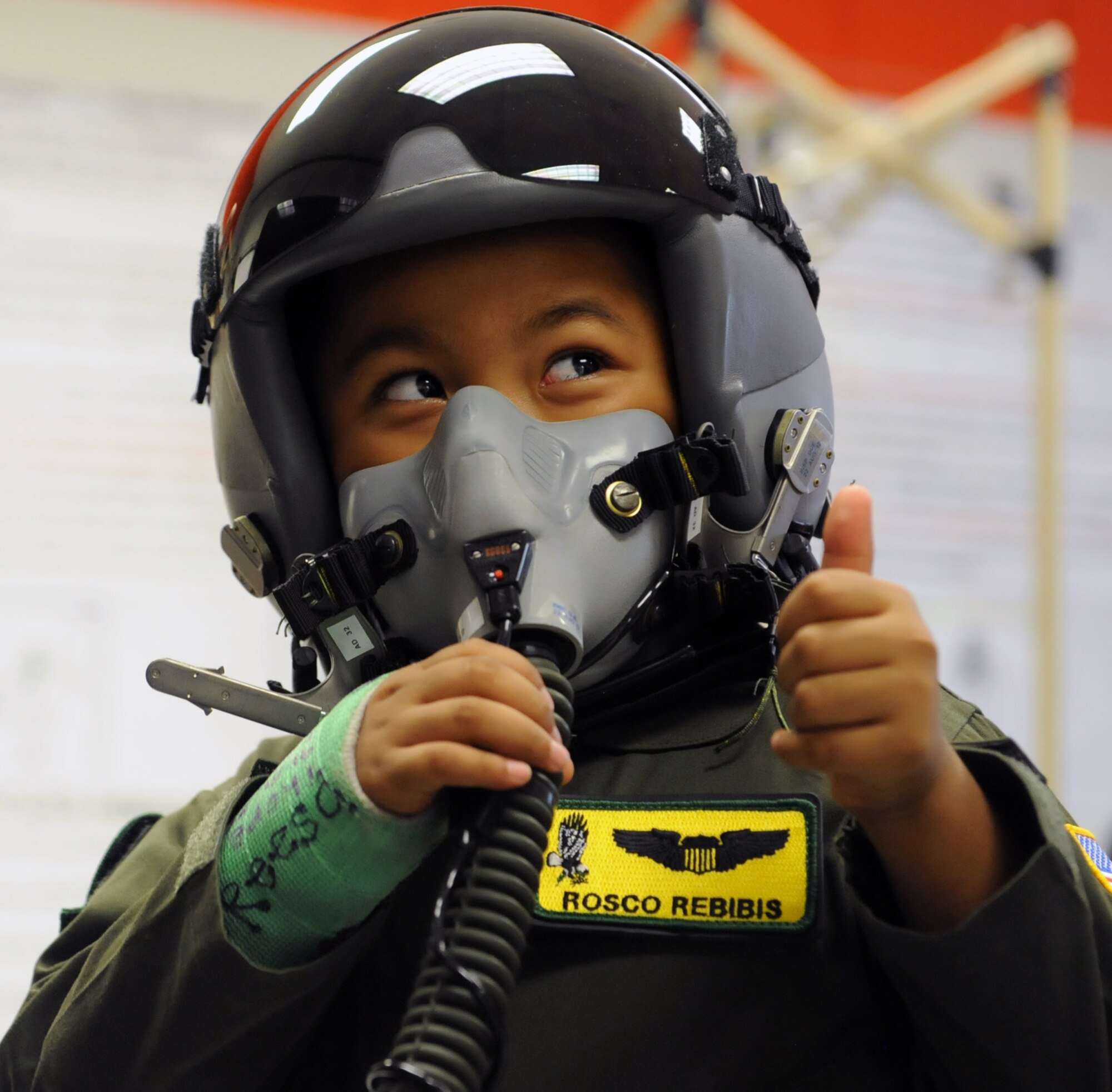 Rosco Rebibis (right), a patient at Kapiolani Medical battling acute lymphoblastic leukemia, gives a thumbs up signifying that air is flowing through the mask, to Master Sgt. Bobby Pickel, 15th Operations Support Squadron NCO-in-charge of KC-135 Stratotanker aircrew flight equipment, June 29 as part of the Pilot for a Day program at Joint Base Pearl Harbor-Hickam, Hawaii. ALL is a cancer of the blood and bone marrow and is the most common type of cancer in children. (U.S. Air Force photo by Staff Sgt. Nathan Allen)
