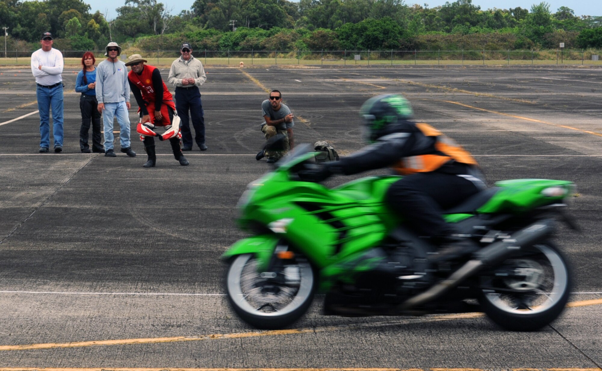 Instructors and coaches watch Jack Hughes, Cape Fox traffic safety program regional coordinator, perform an "error run," an exercise where he intentionally commits a mistake for the coaches and instructors to see in order to make errors easier to spot June 26 while watching students during the upcoming "Motorcycle Track Day" at Wheeler Army Airfield, Hawaii. The voluntary training served as an opportunity for Sailors, Soldiers, Airmen, and Marines stationed on the various military installations around Oahu to receive hands-on coaching of proper riding techniques from a team of instructor coaches. (U.S. Air Force photo by Staff Sgt. Nathan Allen)