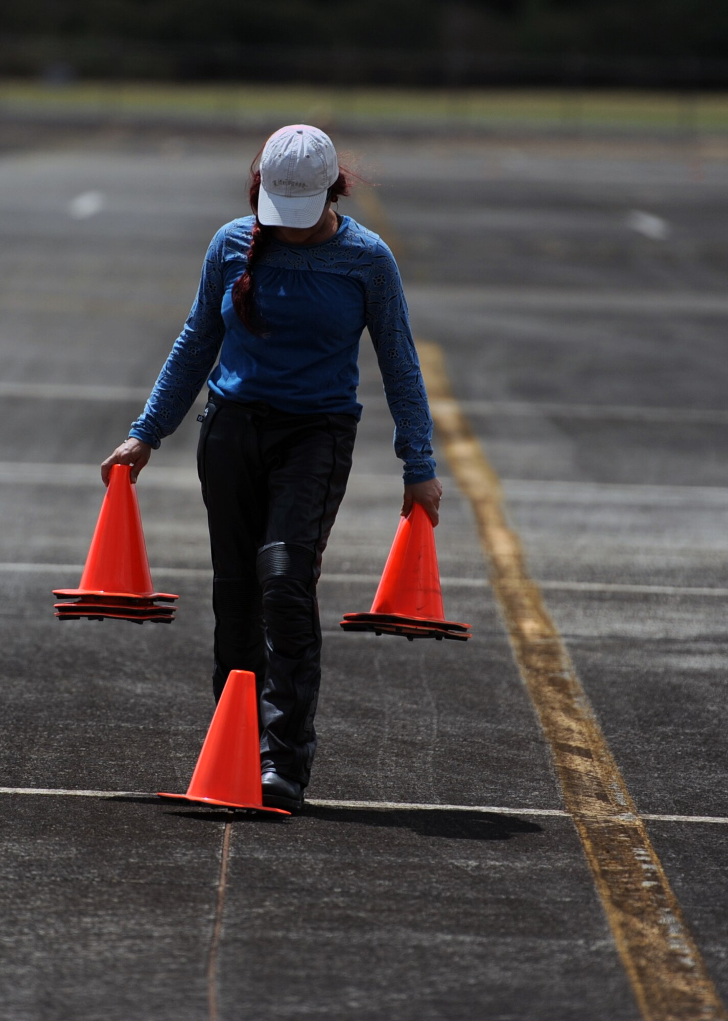 Elizabeth Werter, a rider coach volunteer, sets up the course June 26 for the upcoming "Motorcycle Track Day" at Wheeler Army Airfield, Hawaii. The voluntary training served as an opportunity for Sailors, Soldiers, Airmen, and Marines stationed on the various military installations around Oahu to receive hands-on coaching of proper riding techniques from a team of instructor coaches. (U.S. Air Force photo by Staff Sgt. Nathan Allen)