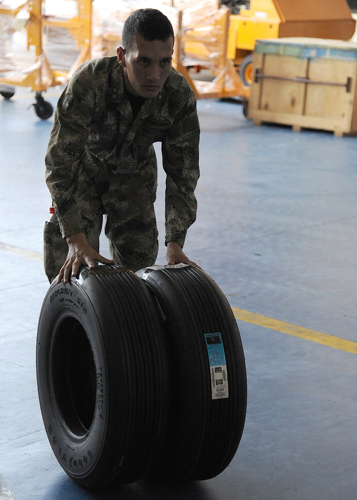A Colombian air force member moves aircraft tires for palletizing during an Air Mobility Command Building Partner Capacity mission at General Alberto Pauwels Rodriguez Air Base in Barranquilla, Colombia, June 27.  (U.S. Air Force photo by Tech. Sgt. Lesley Waters)