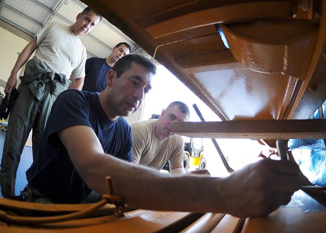 Members of the 571st Mobility Support Advisory Squadron and the Colombian air force, look on as a Colombian air force member labels a generator with the proper weight and balance before loading it onto an aircraft during an Air Mobility Command Building Partner Capacity mission at General Alberto Pauwels Rodriguez Air Base in Barranquilla, Colombia, June 27.  (U.S. Air Force photo by Tech. Sgt. Lesley Waters)