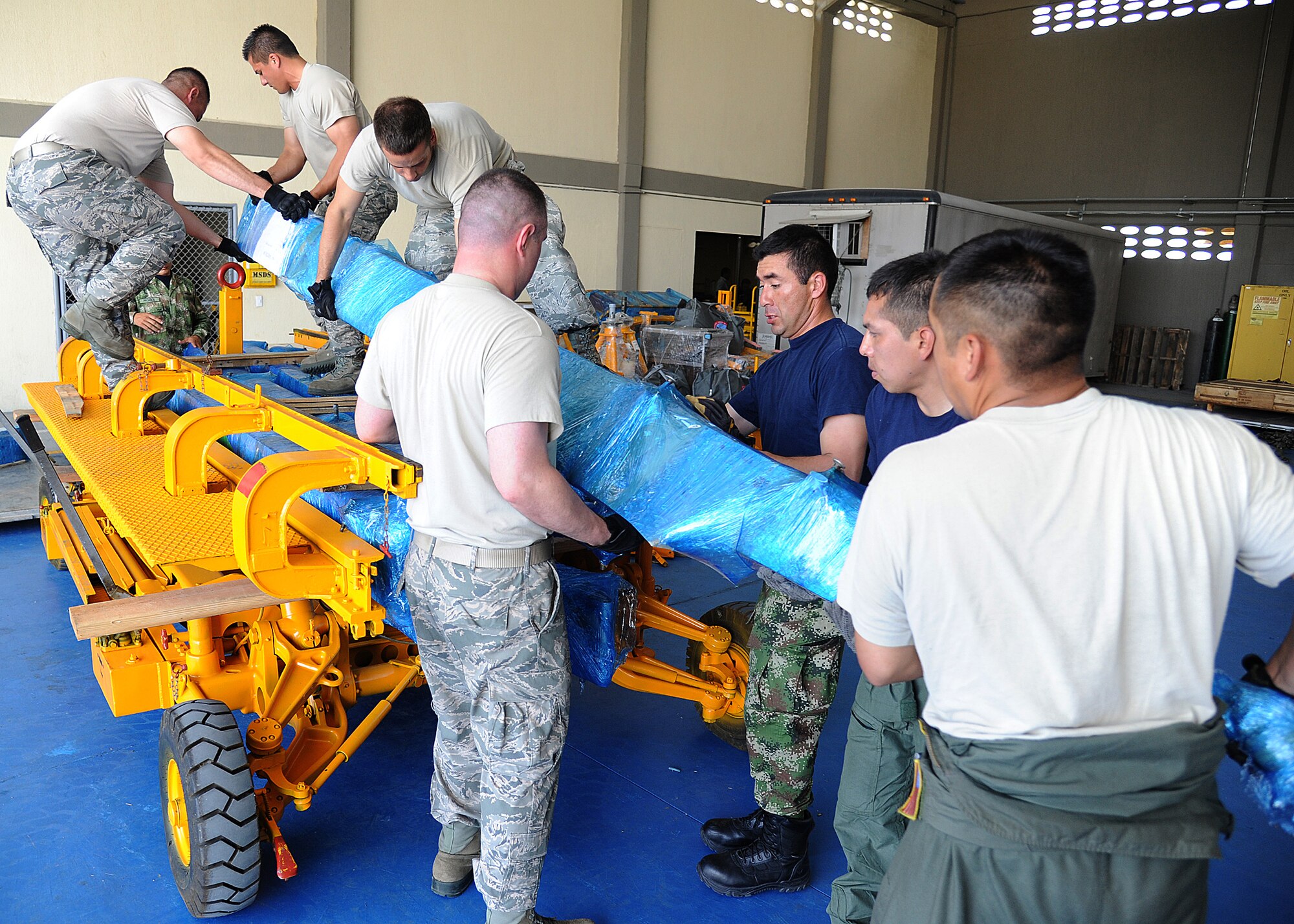 Members of the 571st Mobility Support Advisory Squadron and the Colombian air force, load gear onto rolling stock before weighing and loading it onto an aircraft during an Air Mobility Command Building Partner Capacity mission at General Alberto Pauwels Rodriguez Air Base in Barranquilla, Colombia, June 27.  (U.S. Air Force photo by Tech. Sgt. Lesley Waters)