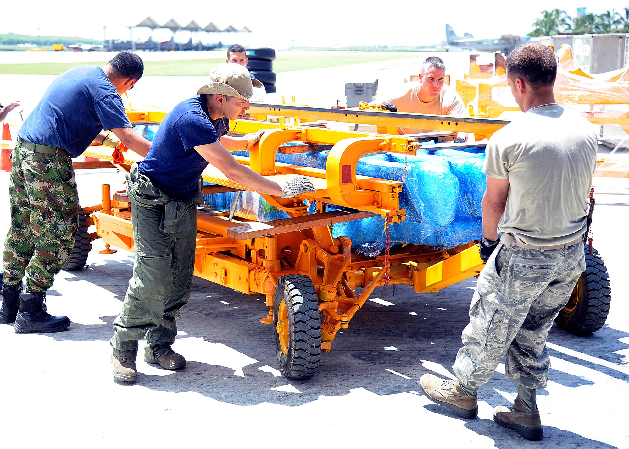 Members of the 571st Mobility Support Advisory Squadron and the Colombian air force, reposition some rolling stock before weighing it during an Air Mobility Command Building Partner Capacity mission at General Alberto Pauwels Rodriguez Air Base in Barranquilla, Colombia, June 27.  (U.S. Air Force photo by Tech. Sgt. Lesley Waters)