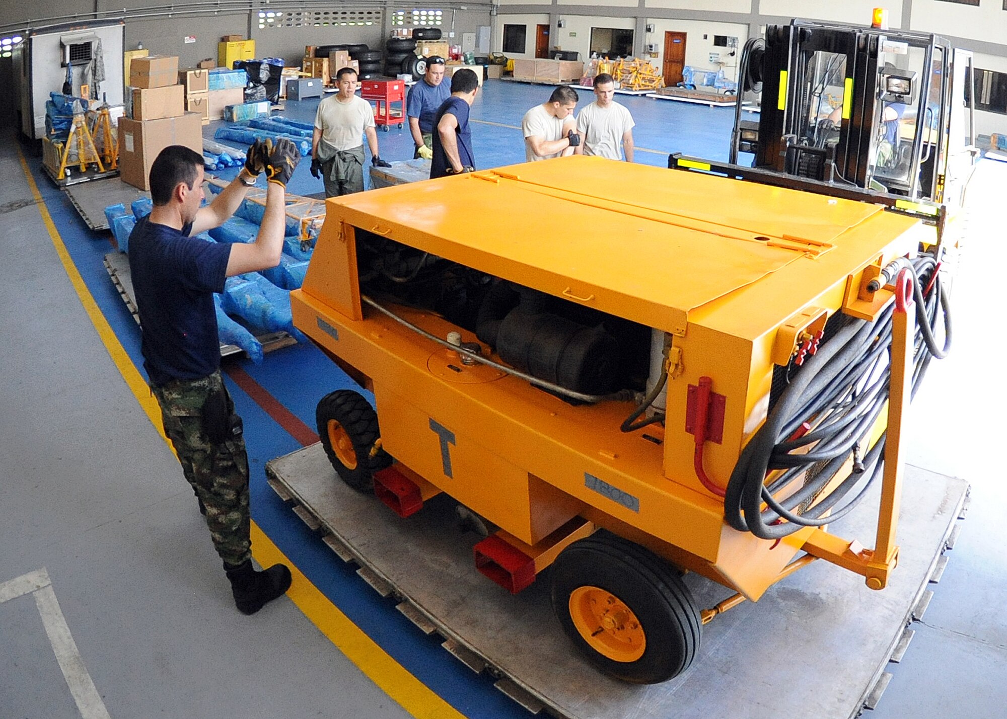 Members of the 571st Mobility Support Advisory Squadron and the Colombian air force, position a generator onto a pallet before loading it onto an aircraft during an Air Mobility Command Building Partner Capacity mission at General Alberto Pauwels Rodriguez Air Base in Barranquilla, Colombia, June 27.  (U.S. Air Force photo by Tech. Sgt. Lesley Waters)